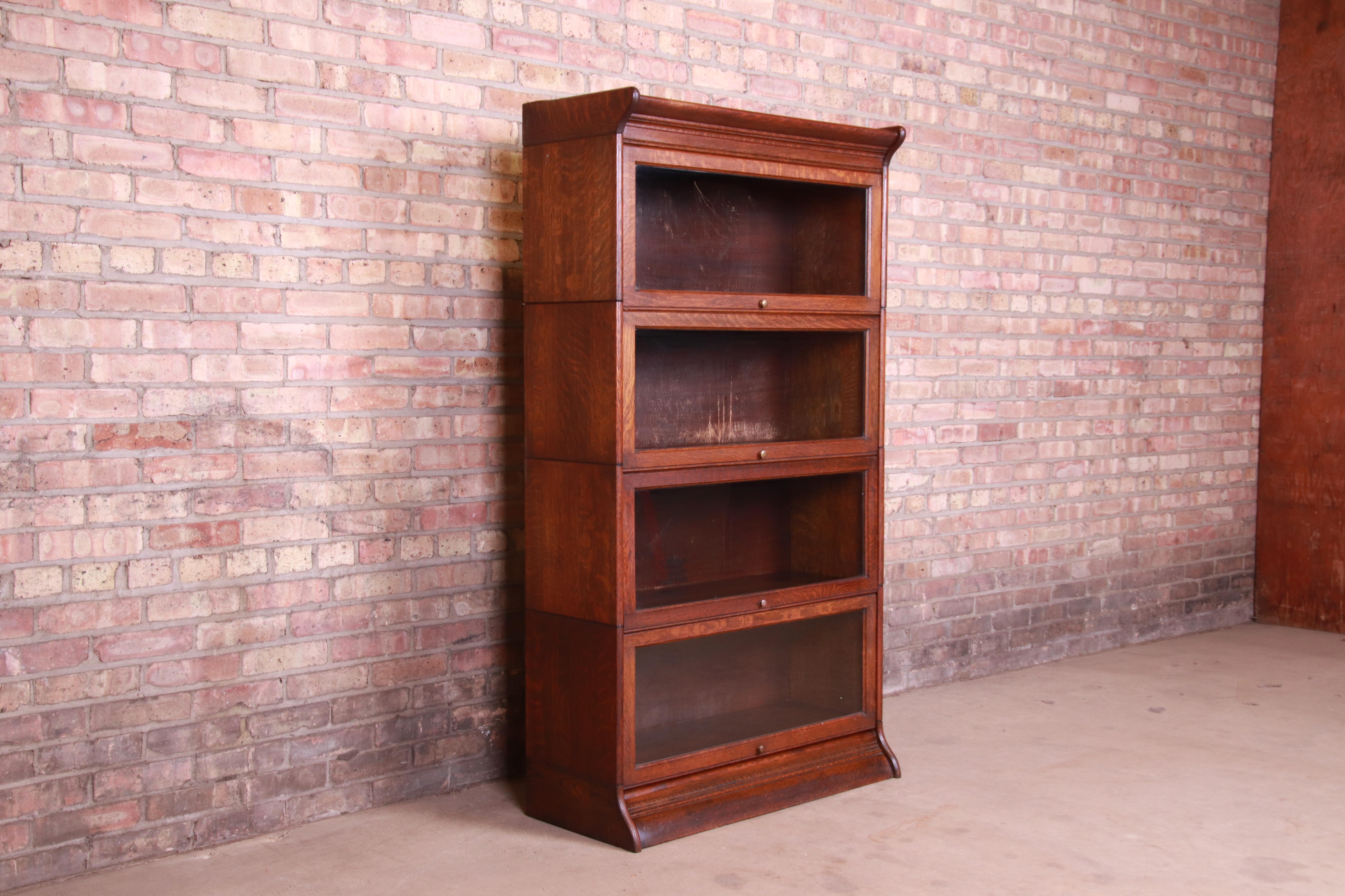 A gorgeous antique Arts & Crafts quartersawn oak four-stack barrister bookcase

Attributed to Gunn Furniture Co.

USA, circa 1920s

Measures: 34.25