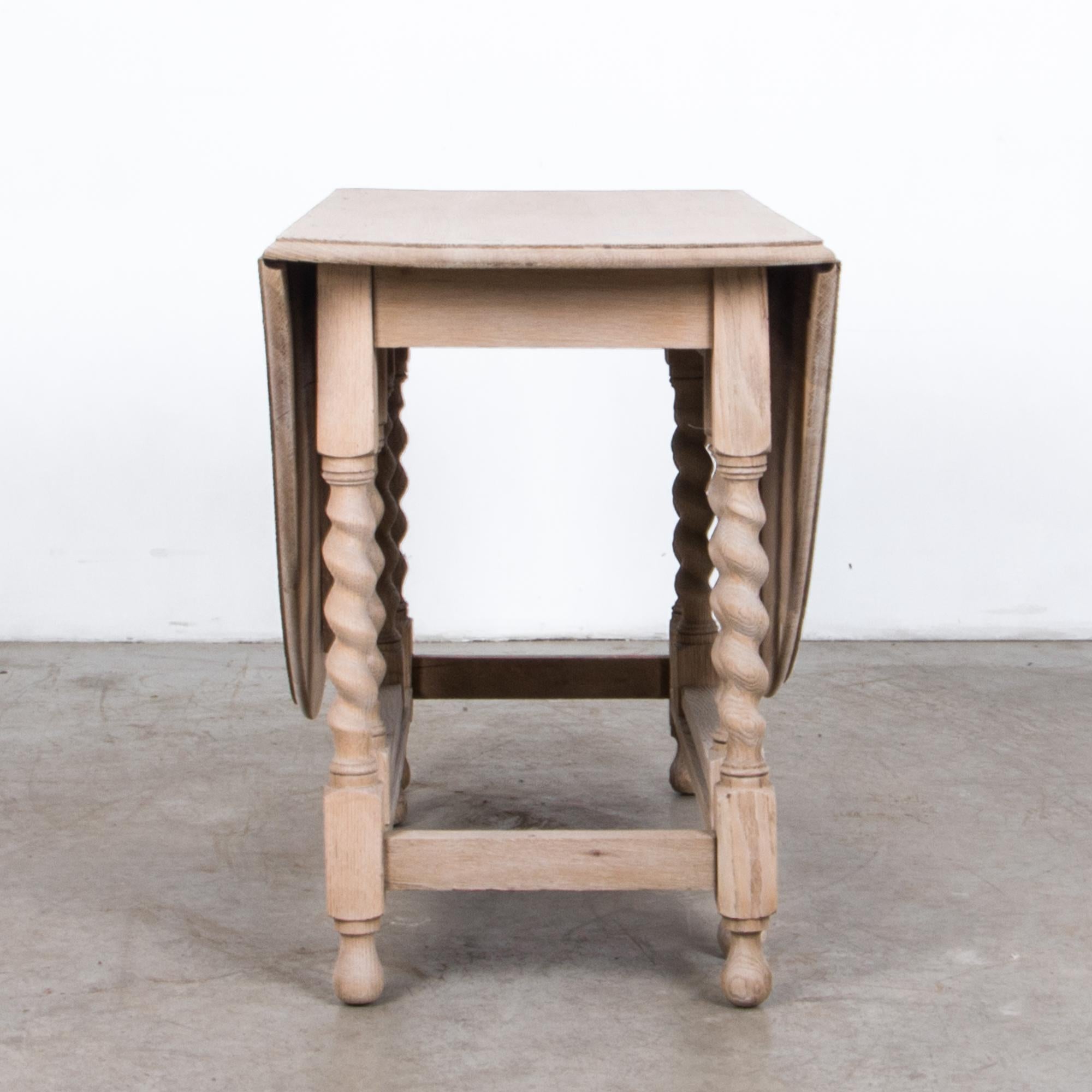 A folding gate leg table from the United Kingdom, circa 1900. The folding gate leg makes this table versatile and practical while retaining stability, and style. Carved details and turned table legs give a classical inflection, “twisted barley