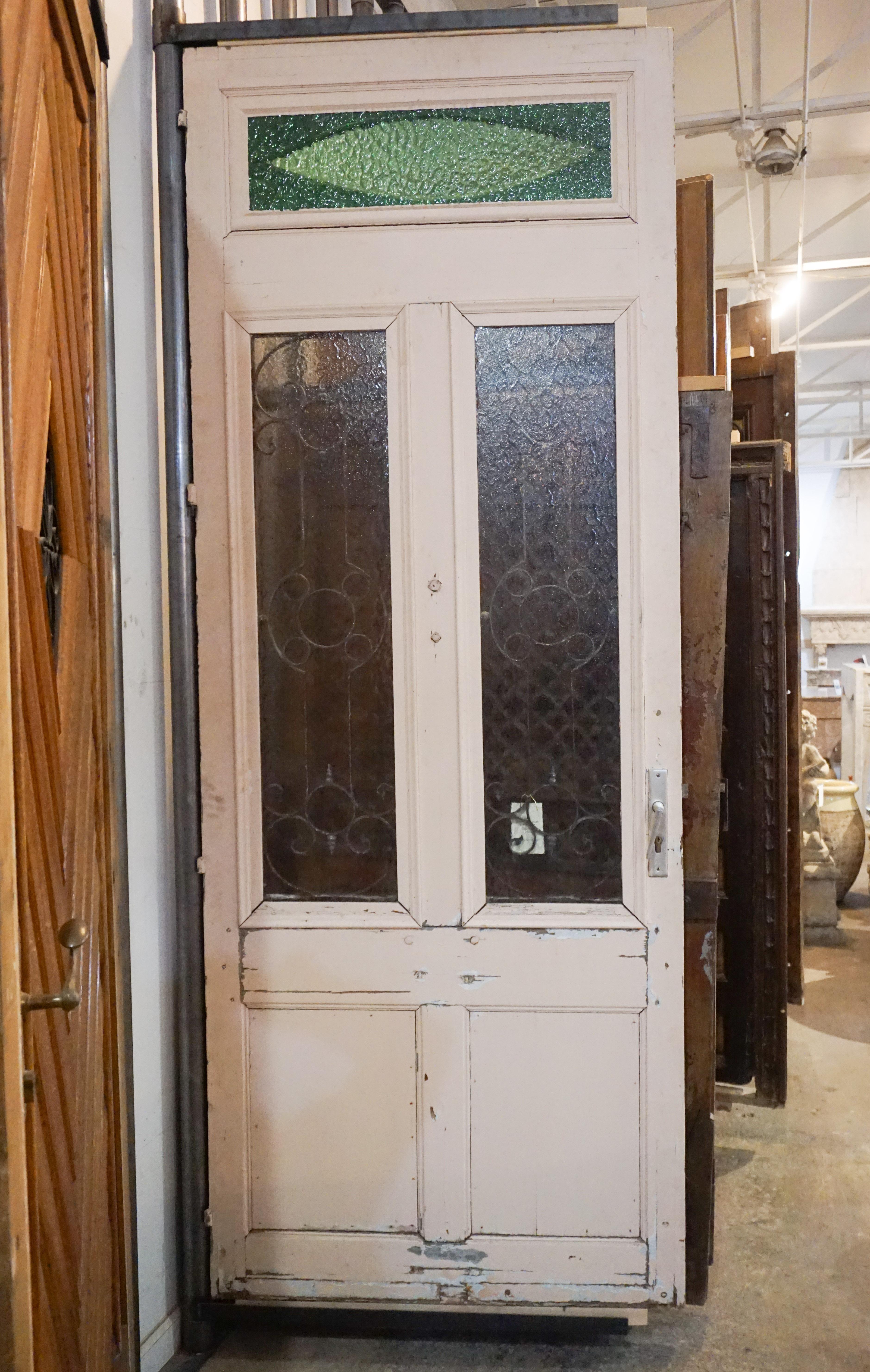Antique oak, glass and iron work door. Imported from France, circa 1870. This door has tons of character with the hand shaped knocker and green textured window transom.

Measurements: 1.5