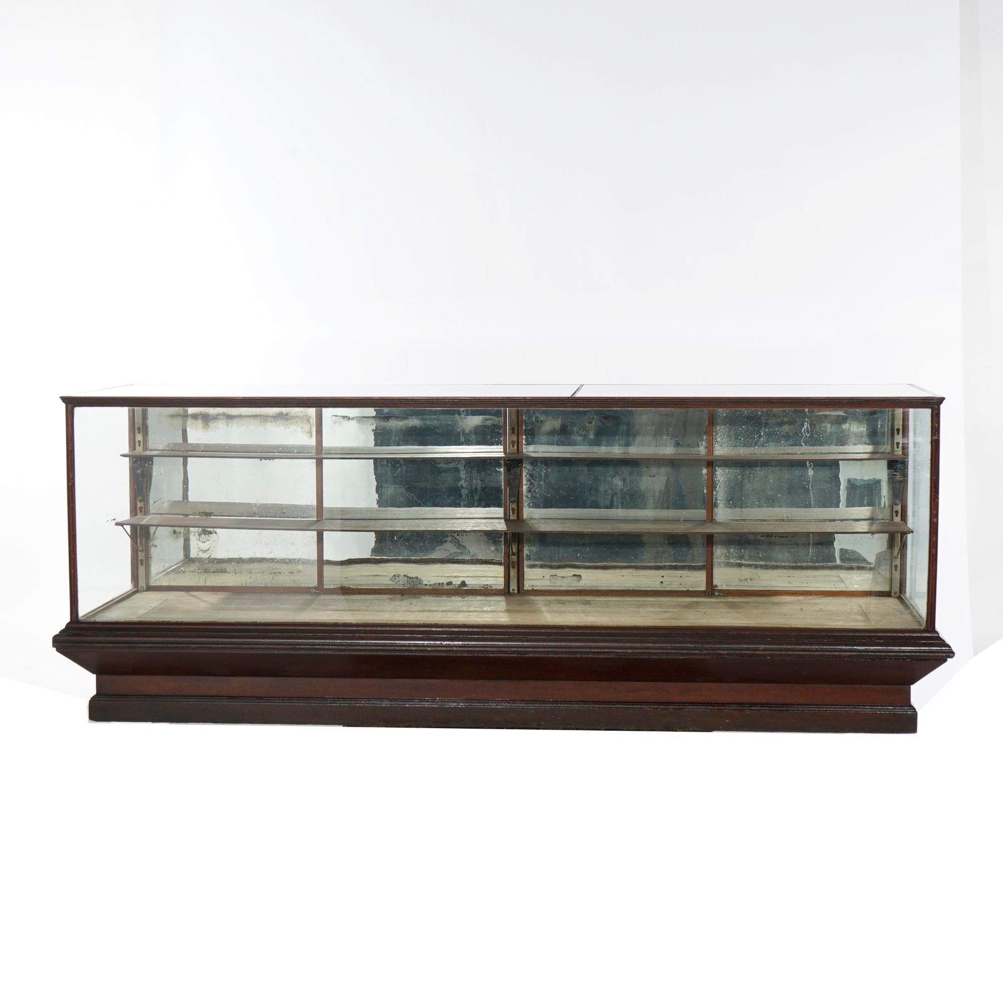 An antique country store counter display case offers oak construction with sliding mirrored glass doors opening to shelved interior and lower drawers, c1900.

Measures- 36''H x 96.5''W x 31.5''D.

*Ask about DISCOUNTED DELIVERY rates within 1,500