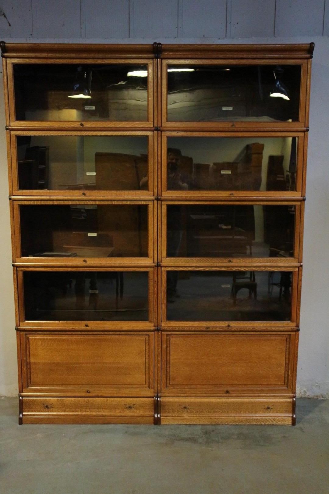 Beautiful antique oak Globe Wernicke bookcase. in perfect condition. The cabinet consists of 10 large stackable parts, the lower ones have a wooden panel. The plinths are also fitted with drawers. All parts are suitable for file binder size books.