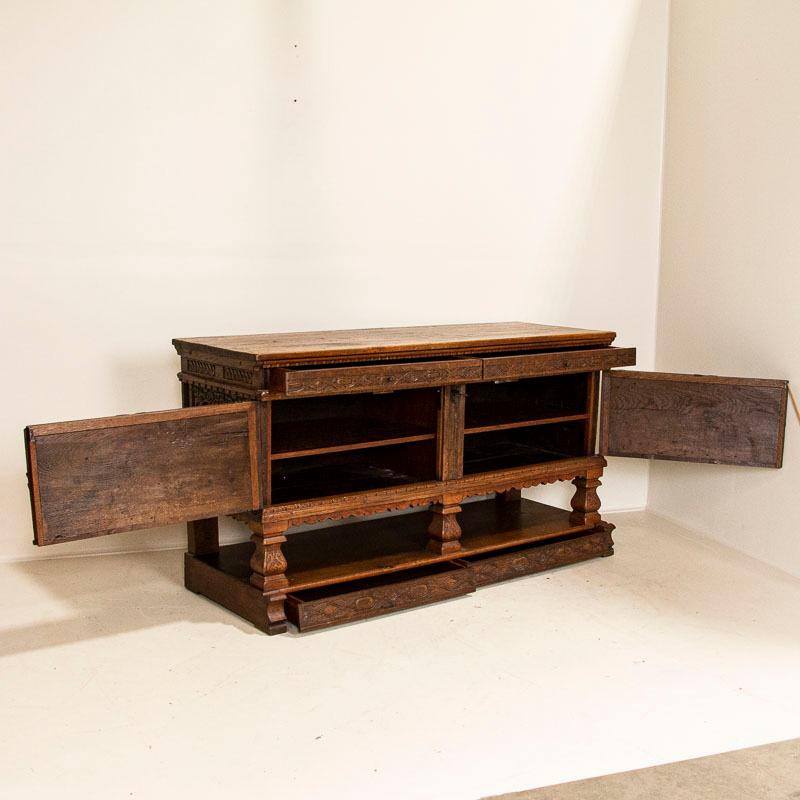 The intricate hand carved details highlight the natural beauty of the oak in this impressive large sideboard. Please enlarge and examine the close up photos to appreciate the craftsmanship and patina of the aged wood. The upper and lower drawers run