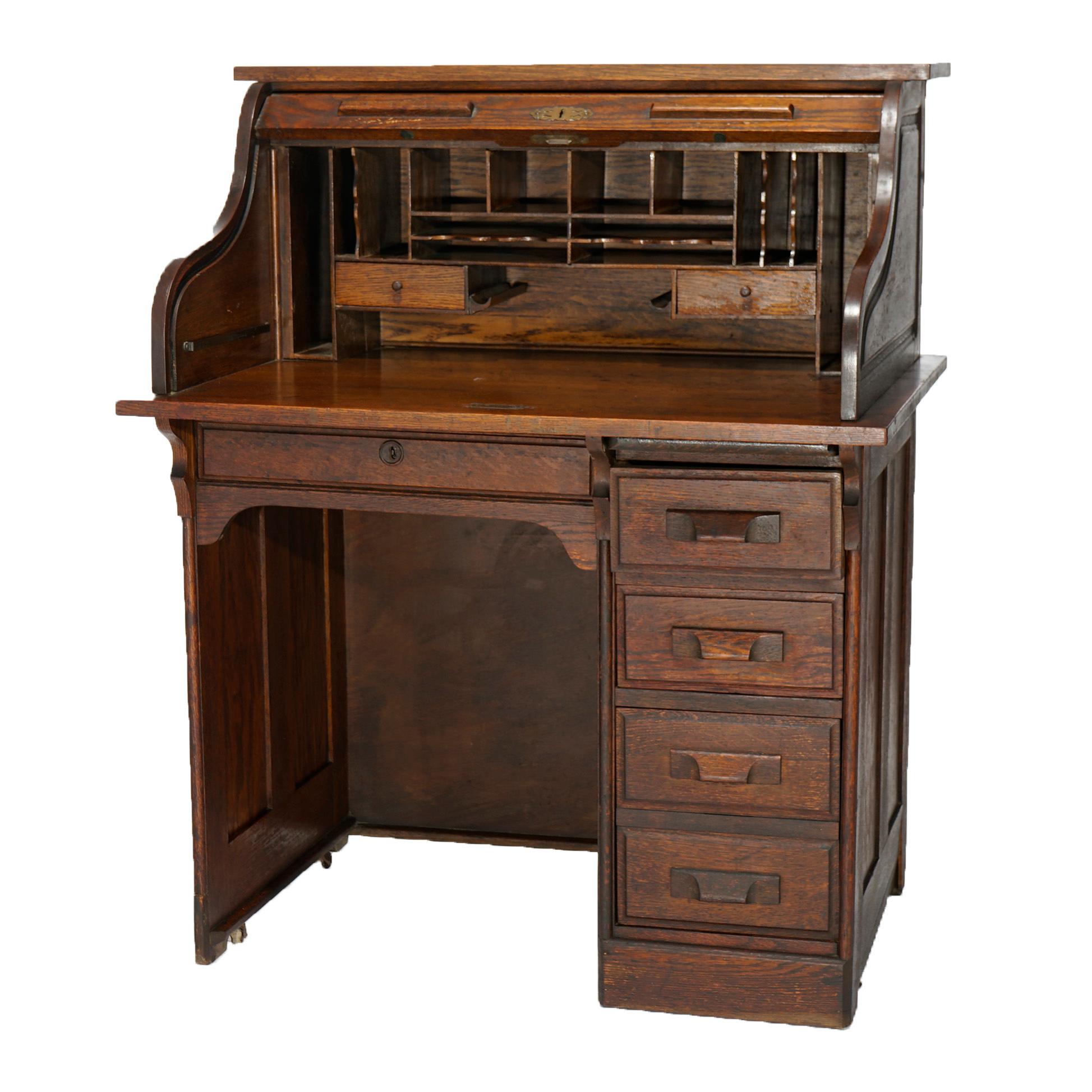 An antique ladies desk offers paneled oak construction with s-roll top opening to compartmentalized interior over base with single drawer column, includes two keys, c1910

Measures- 45.25''H x 36.25''W x 26.25''D.