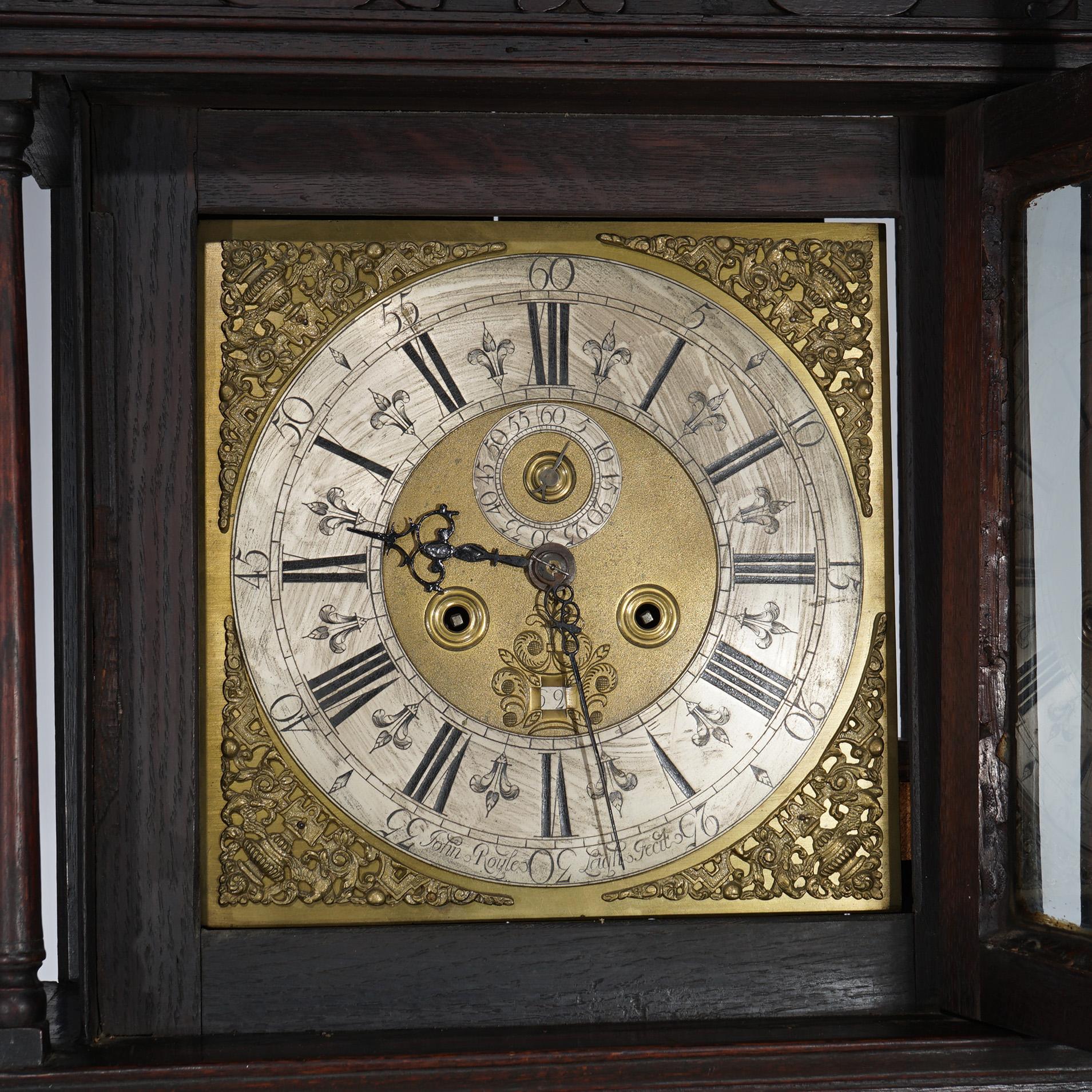 An antique tall case clock offers oak case with face having 