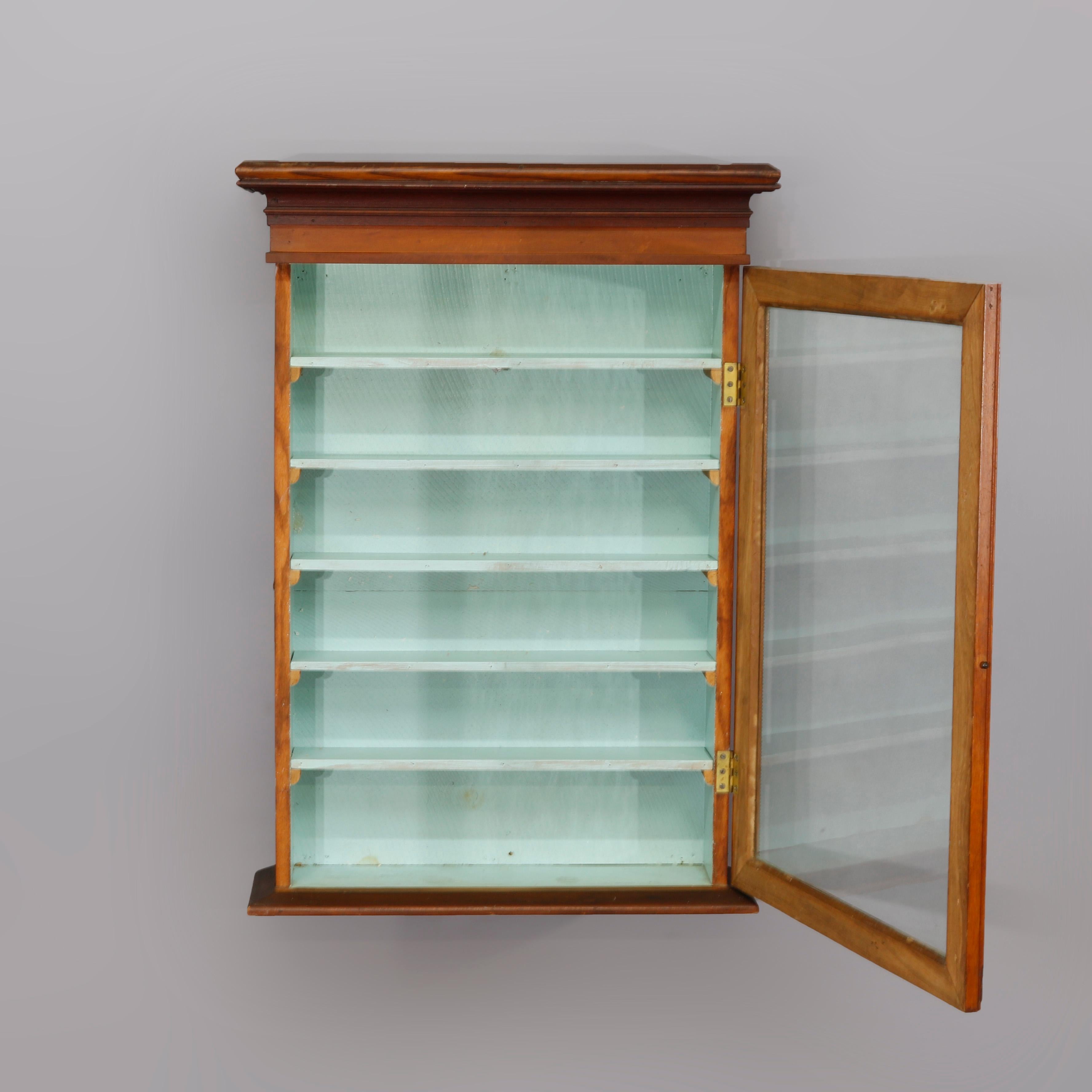 An antique hanging display wall cabinet offers mahogany and oak construction with glass door opening to shelved interior, circa 1900

Measures: 35.13