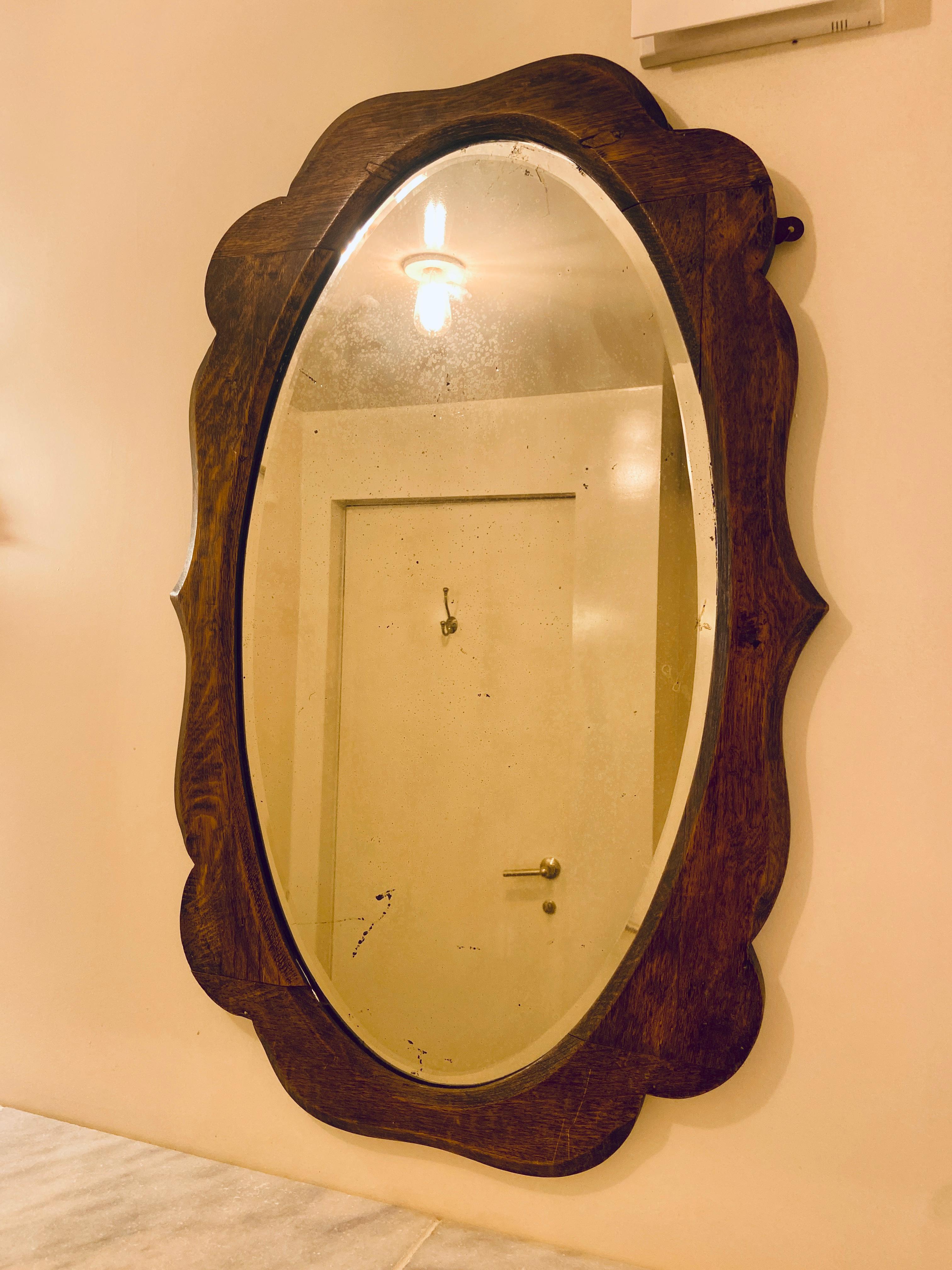 A beautiful antique oak mirror made in England around the end of the 19th/beginning of the 20th century.

Gentle foxing visible on the glass.