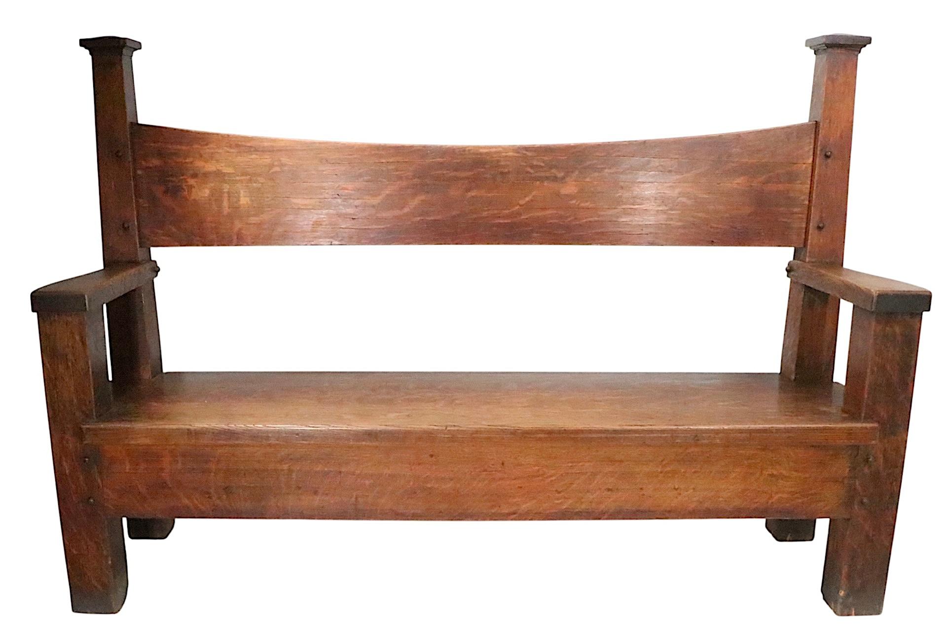 Incredible Mission, Gothic, Arts and Crafts style settee, bench, constructed of quarter sawn oak, and oak veneer. The bench features back supports with pyramid form capitals, a dramatic swooped backrest, back legs that taper towards the top. The