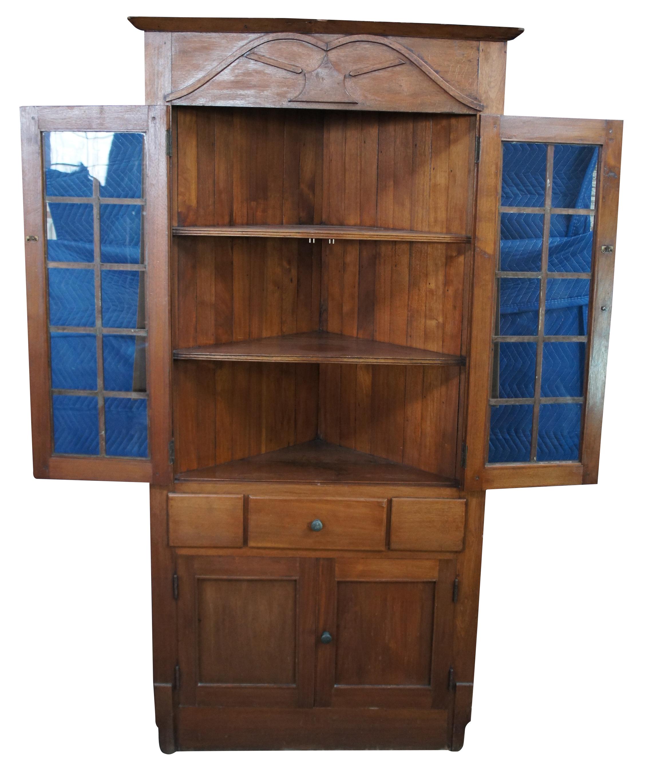 Antique oak corner display cabinet, curio or cupboard featuring upper cabinet with three shelves, central drawer and lower cabinet.
 