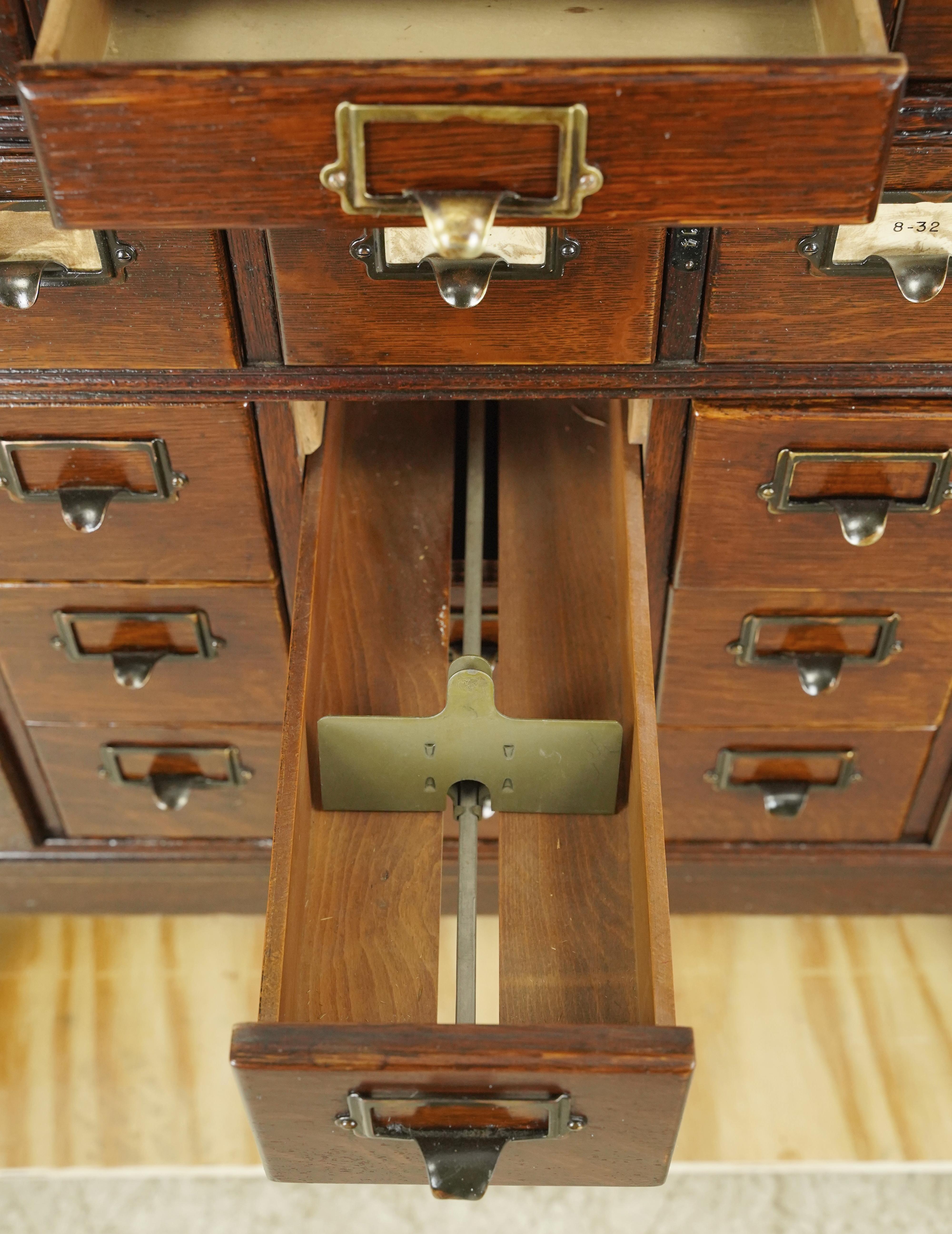 Antique oak card catalog cabinet with 51 drawers in five modular stackable pieces. Each drawer has a brass drawer label slot pull. Good condition with surface wear from prior use. One available. Please note, this item is located in our NYC location.