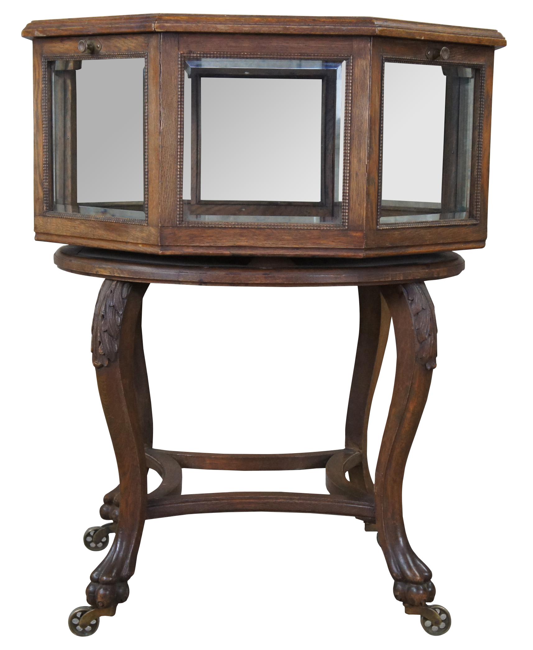 An exquisite and rare Victorian octagonal shaped Vitrine or Bijouterie,  Last quarter of the 19th century.  Made of quartersawn oak featuring rotating top with beveled glass, four drop front doors over serpentine legs with claw feet and
