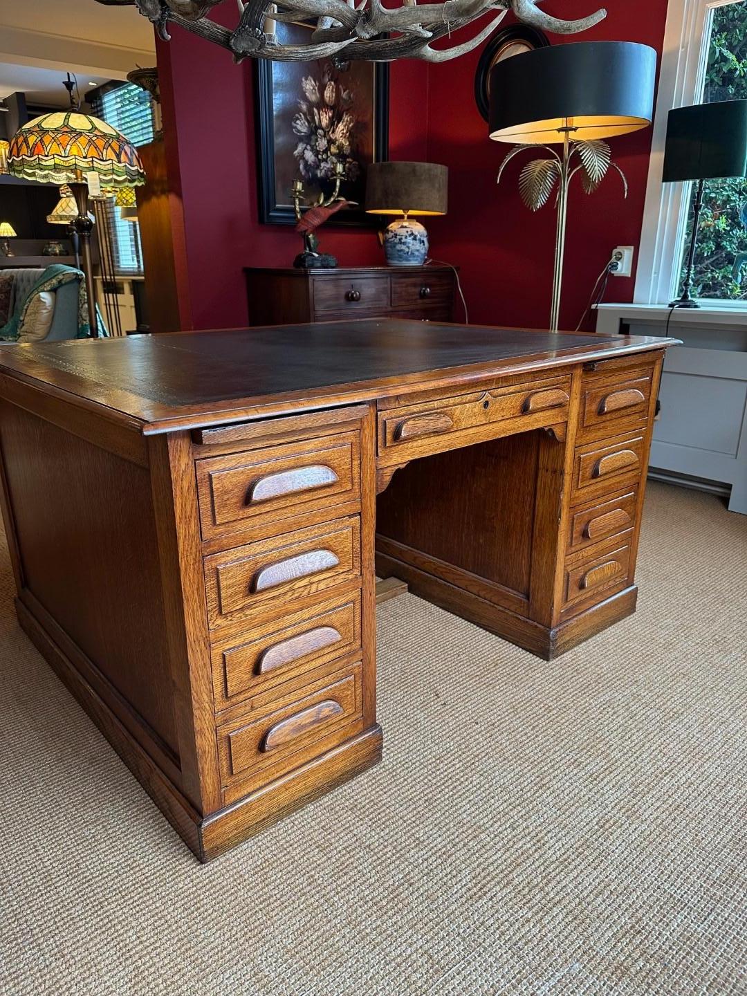 Beautiful antique oak partner desk with 9 drawers on both sides, 1 of which is a double archive drawer. Dark green gold-edged leather top. Desk is in perfect condition. Nice warm color. For more legroom, the center drawer can be removed and put back