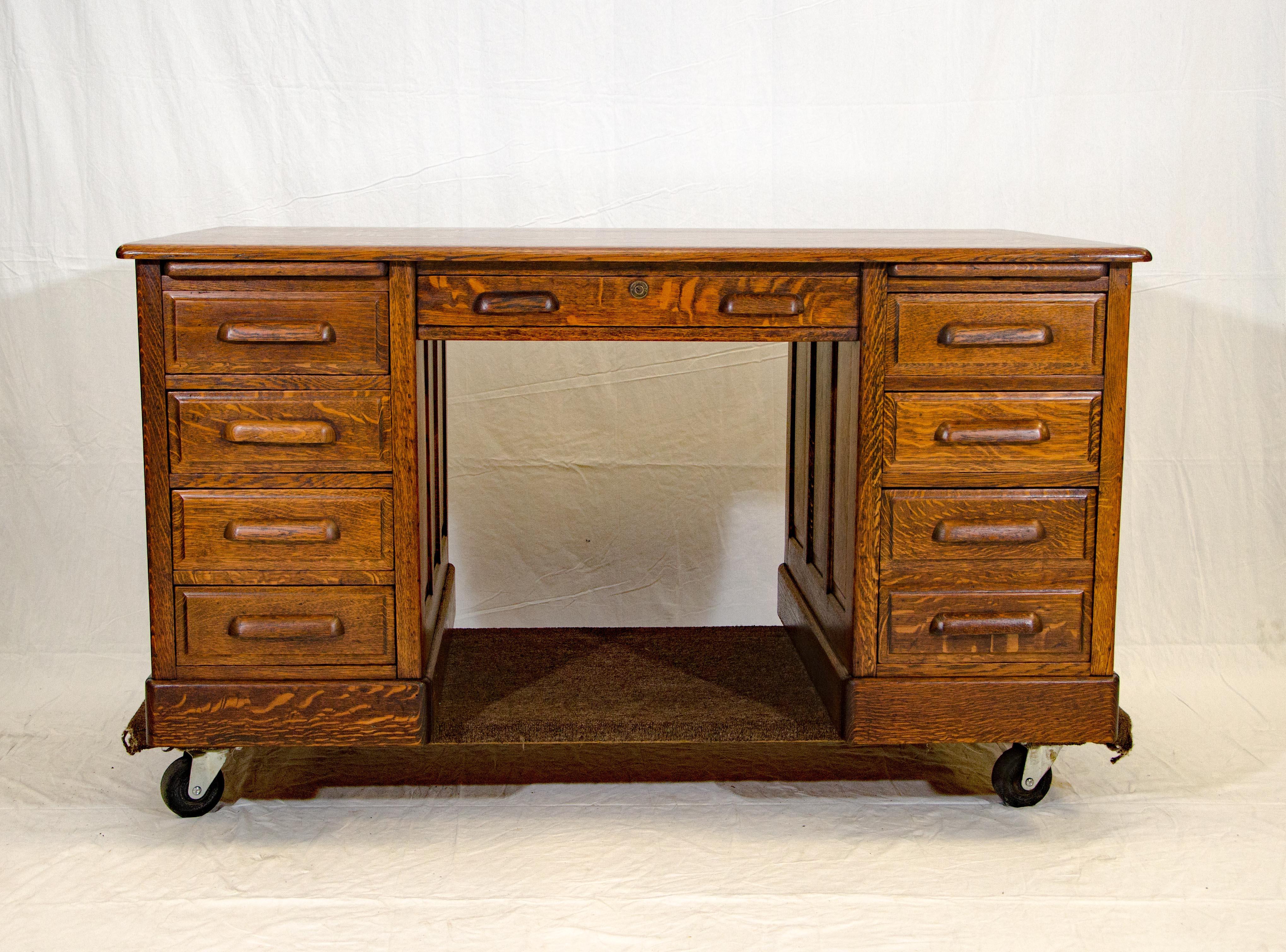A very nice antique oak desk from the turn of the century, the oak is quarter-sawn and exhibits beautiful grain patterns. The four left-hand drawers have an interior height of 4