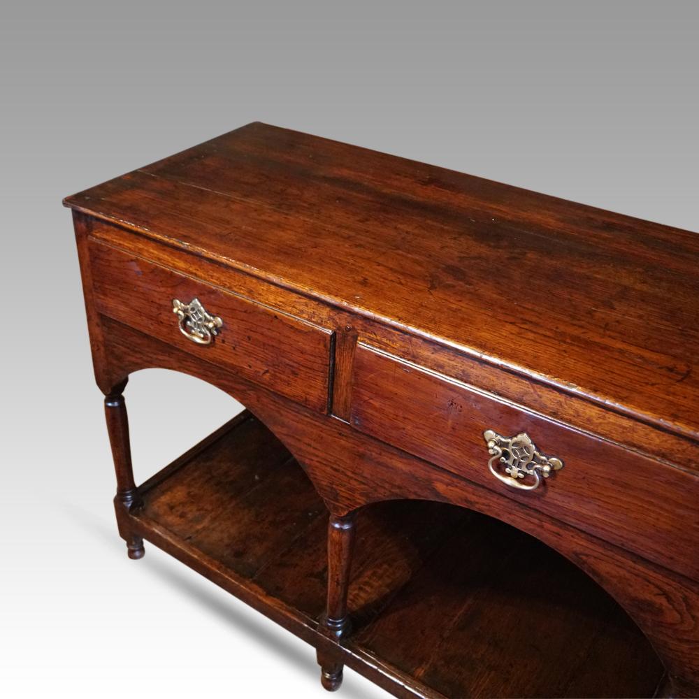 Antique oak pot board dresser base 
This Antique oak pot board dresser base was made circa 1800.
It has the attractive triple arches along the front under the 3 drawers, that have pierced brass swing handles.
Under the arches are the finely turned