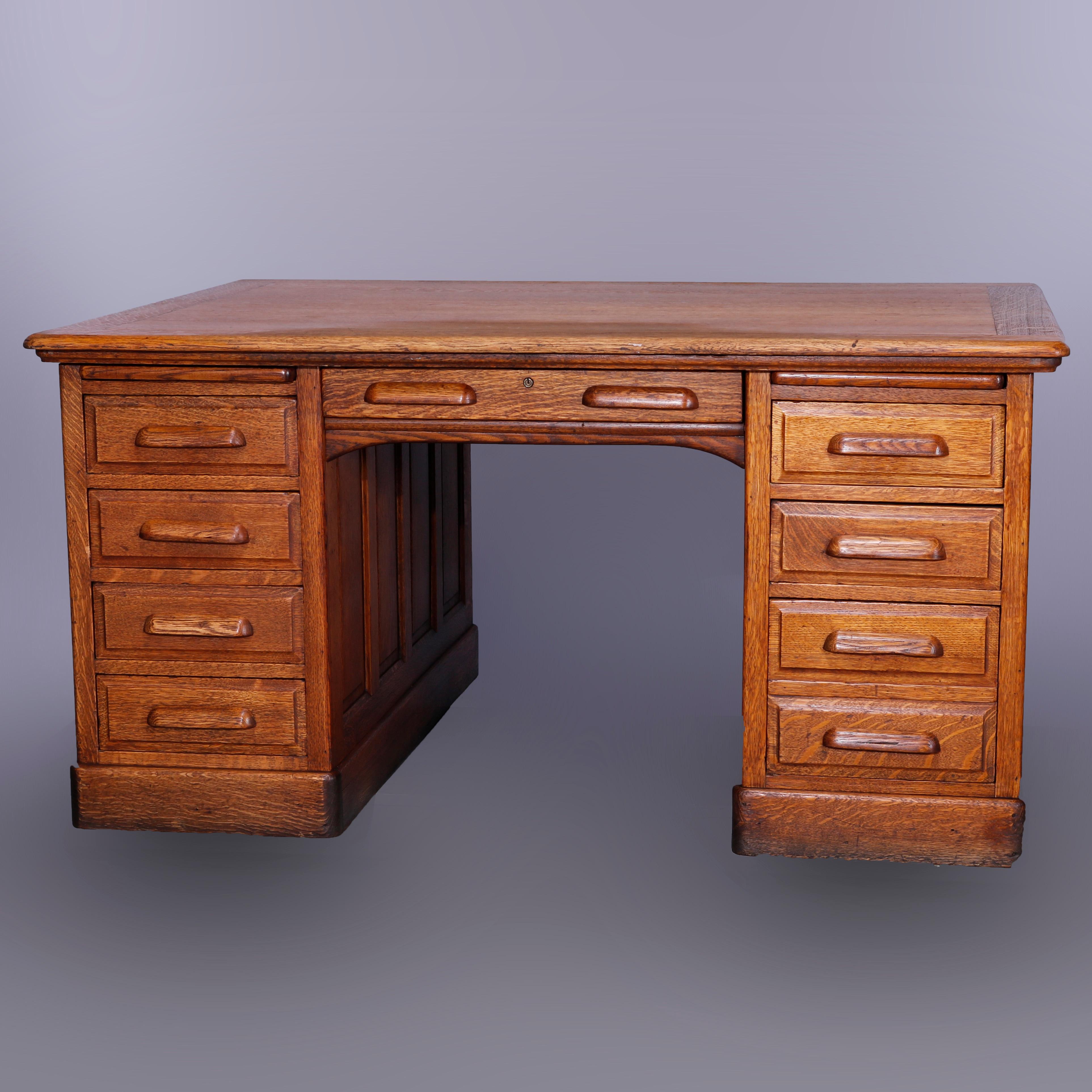 An antique partners desk offers oak raised panel construction with flanking drawer towers, c1900

Measures - 30.25'' H x 59.75'' W x 48'' D.