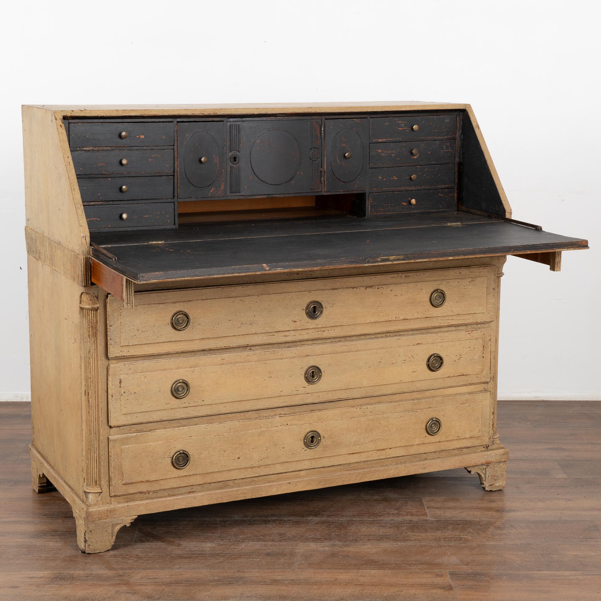 This oak secretary reflects the refined grace and style of early 1800's Denmark. The fluted carving along the mid-section and half columns at sides adds a decorative touch to the drop down desk. 
The traditional interior has small drawers and
