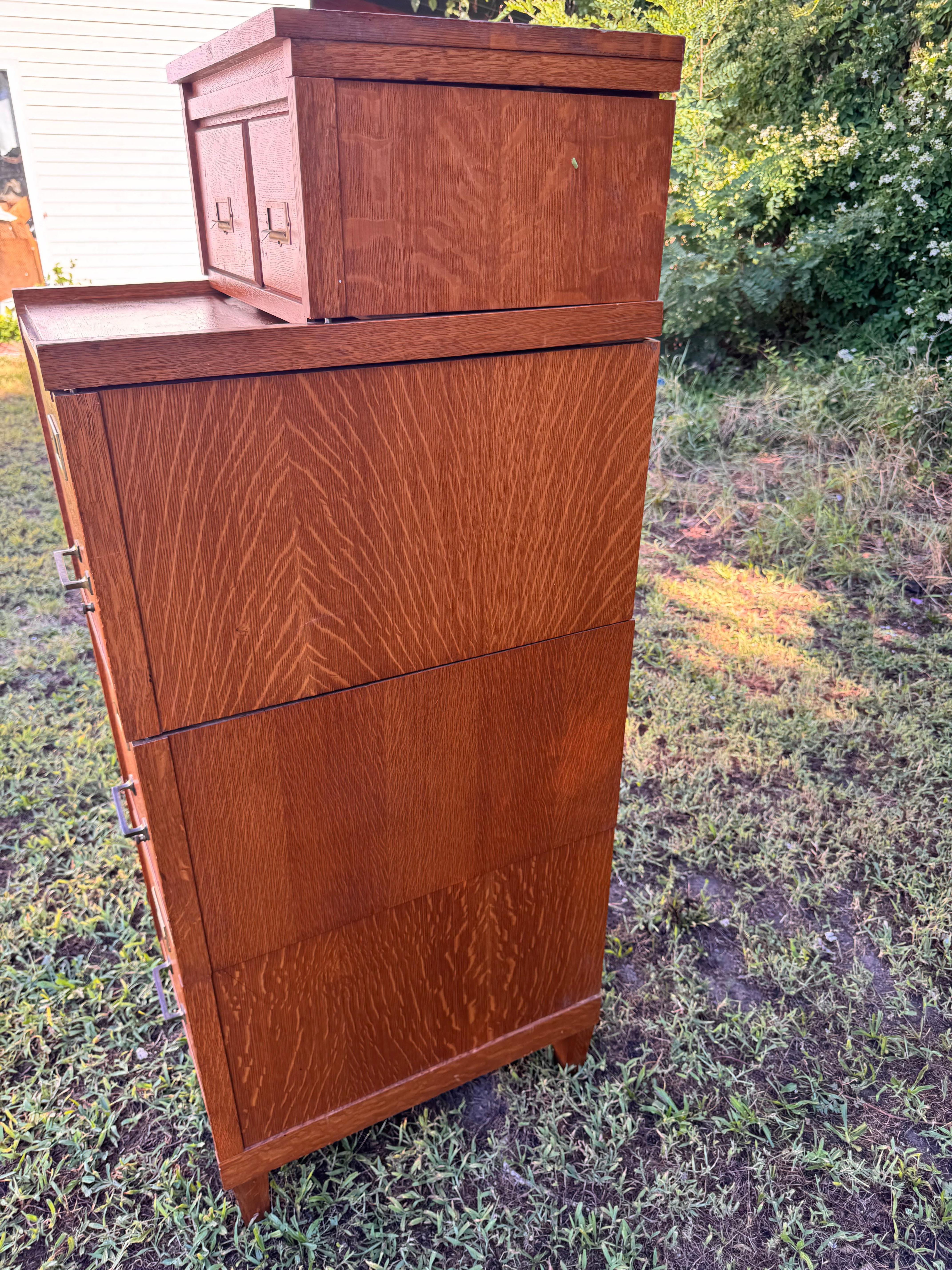 Se trata de un llamativo Archivador seccional antiguo de Roble en muy buen estado.  Fue fabricado a principios del siglo XX por la Weis Manufacturing Company de Monroe, Michigan.  El conjunto incluye una base, tres secciones de cajones de archivo,