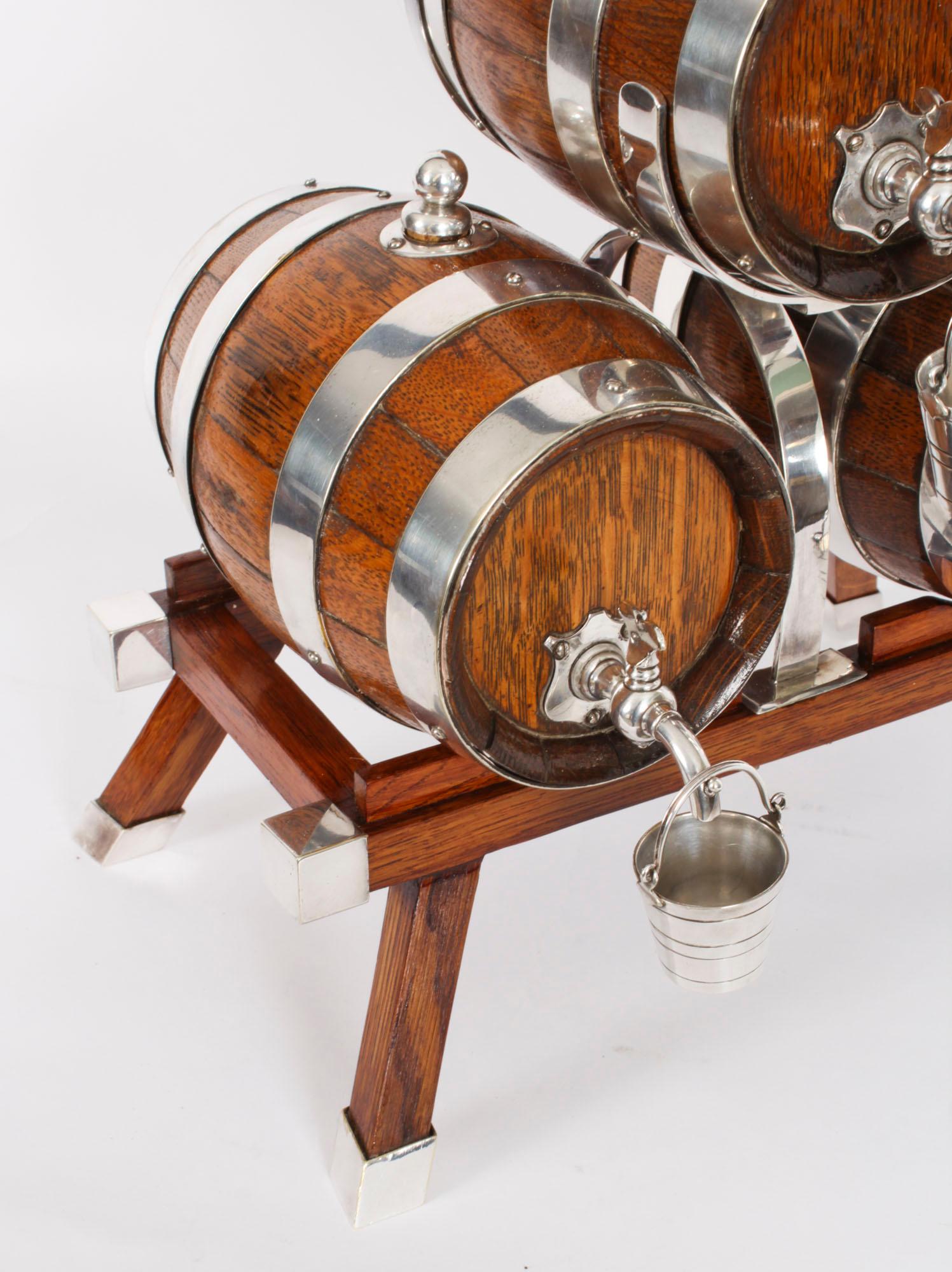 This is an elegant antique solid oak and silver plated three-barrel decanter set, circa 1880 in date. 

The oak trestle stand is formed as  three coopered oak barrels with silver plated straps and taps on an oak trestle stand with decorative
