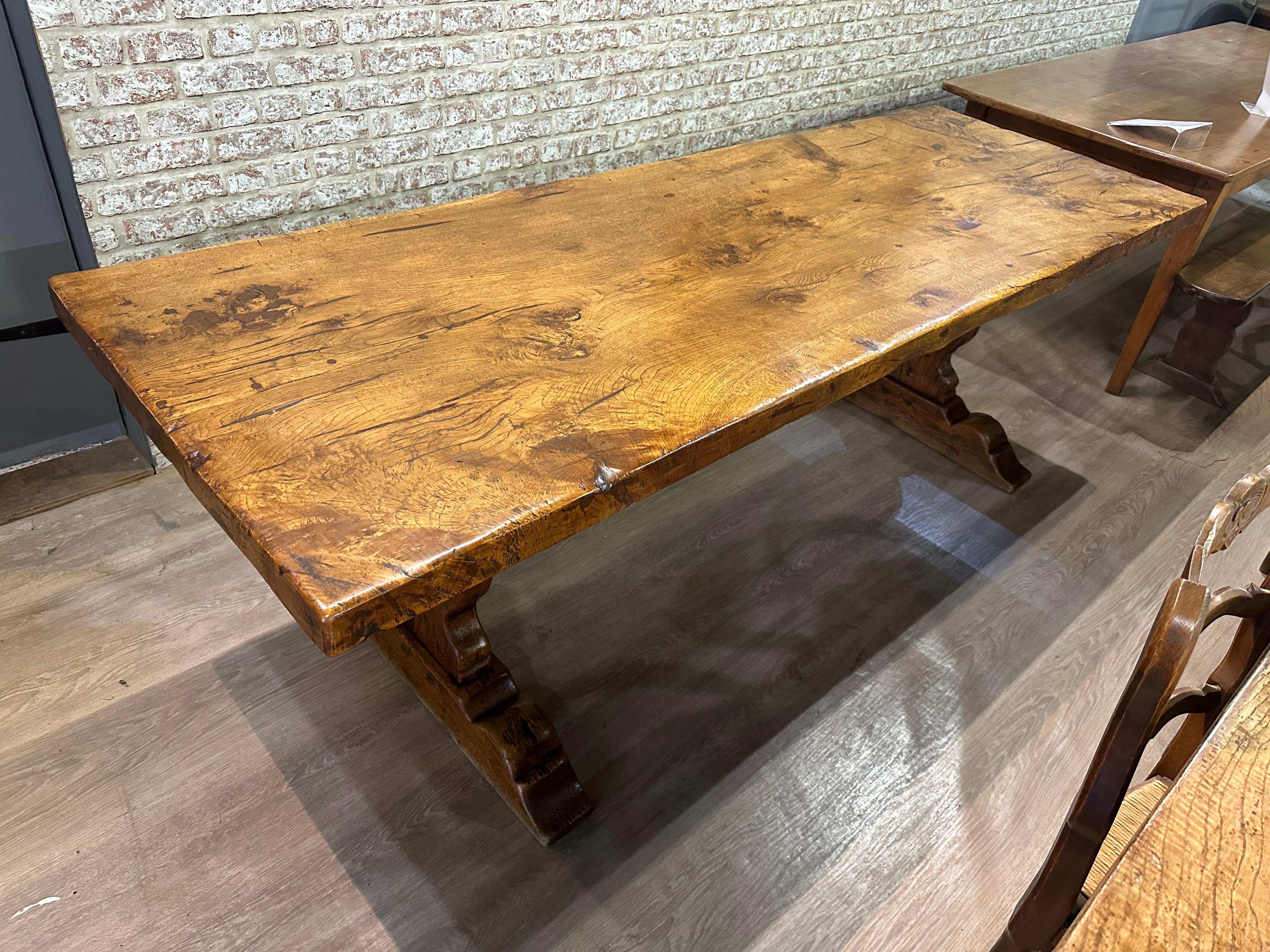 The antique oak single plank top trestle table is a stunning piece with a rich history. Its remarkable patination and colour add to its charm and character. The table features a rare single plank top that showcases beautiful figuration, adding a