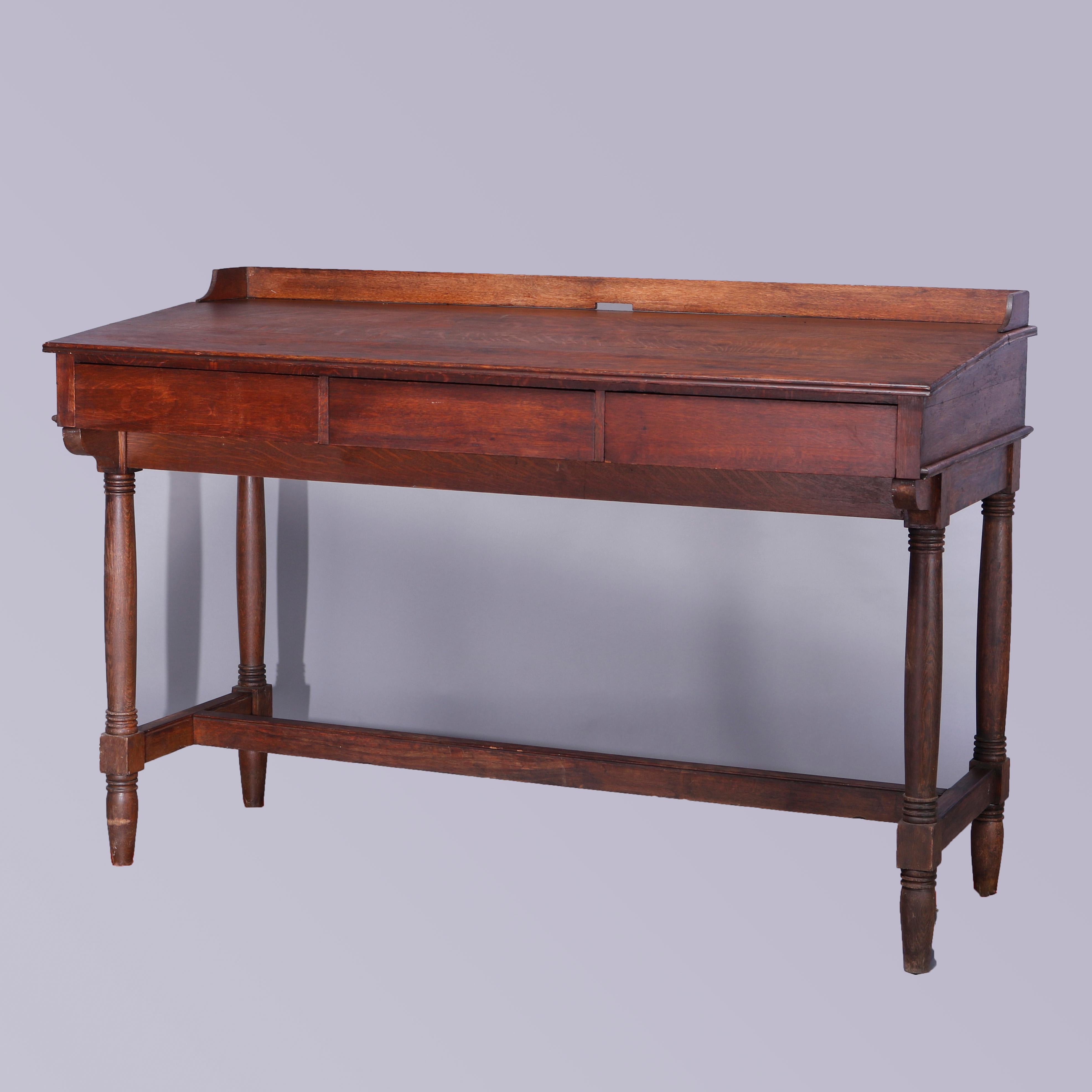 An antique railroad station desk offers oak construction with slat front having backsplash and three drawers, raised on turned legs with H-stretcher, c1900 

Measures- 48.5''H x 71.5''W x 32.25''D.