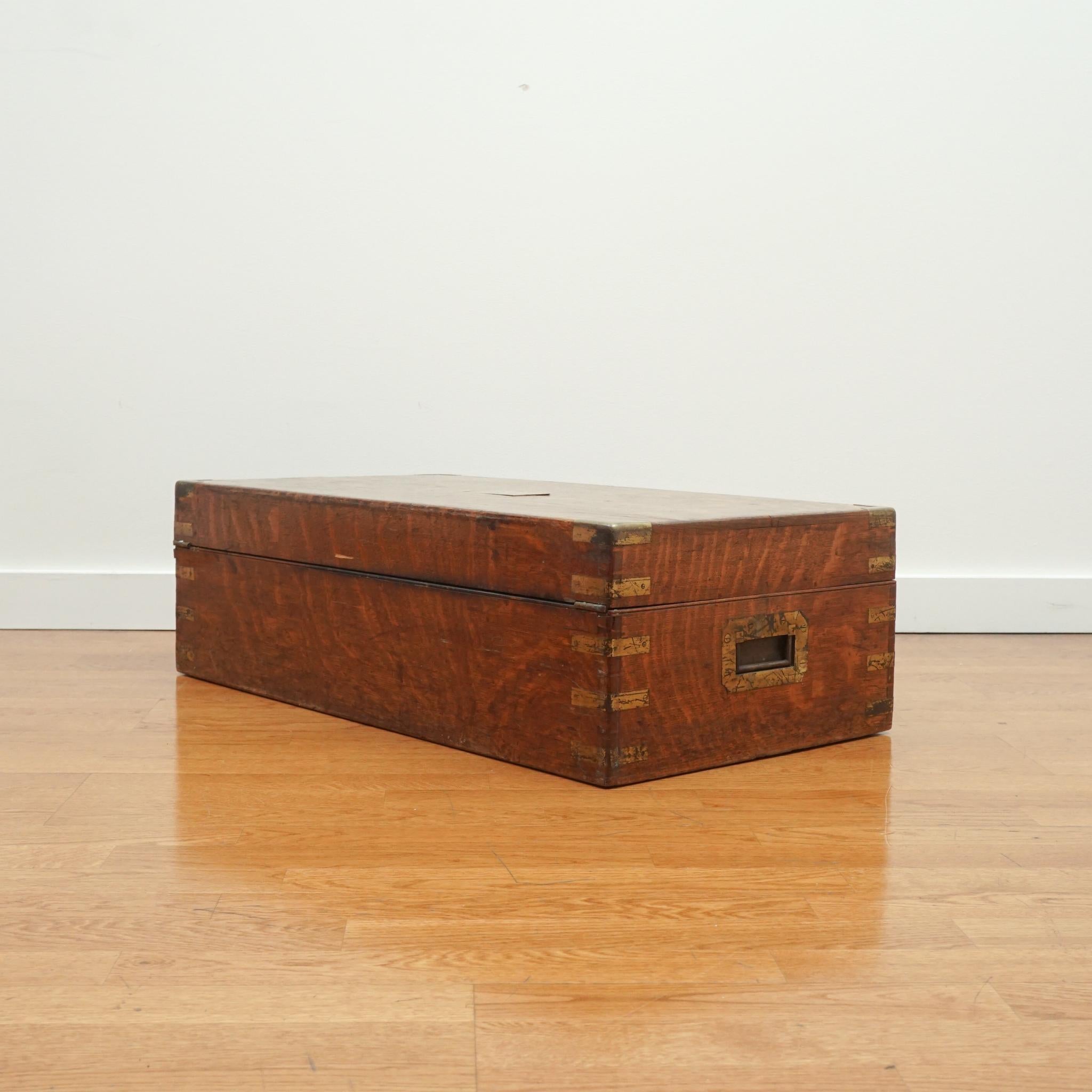 The antique oak storage box, shown here, is as decorative as it is practical.  Made in the 1840s-1850s, the box is solidly crafted of oak and fitted with brass corner braces and corner guards, and an unmarked brass center plate.  The interior offers