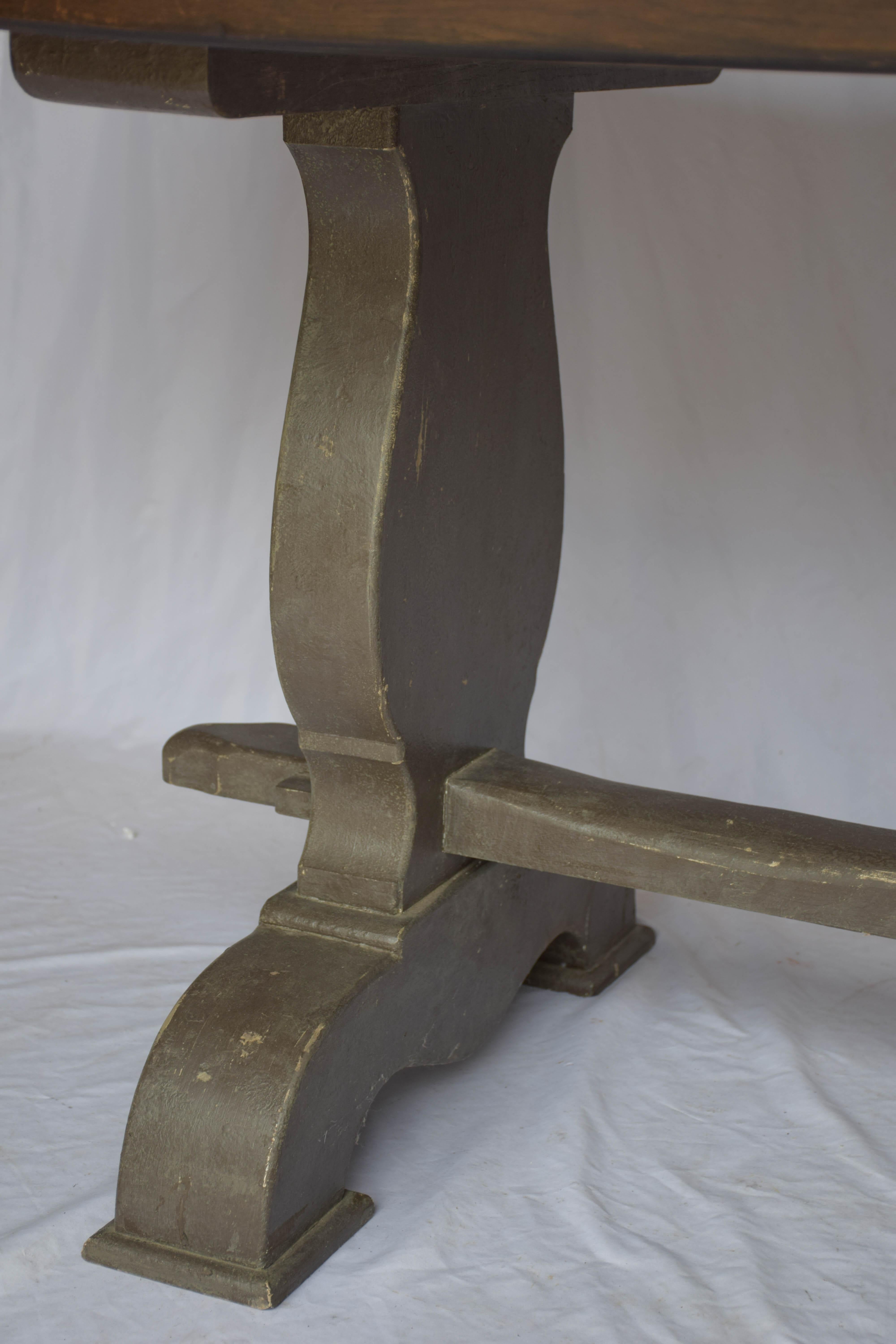 Il tavolo antico in rovere con base dipinta è stato trovato in Francia. Riteniamo che la parte superiore sia stata aggiunta alla base in un momento diverso. Ha un grazioso intarsio a 
