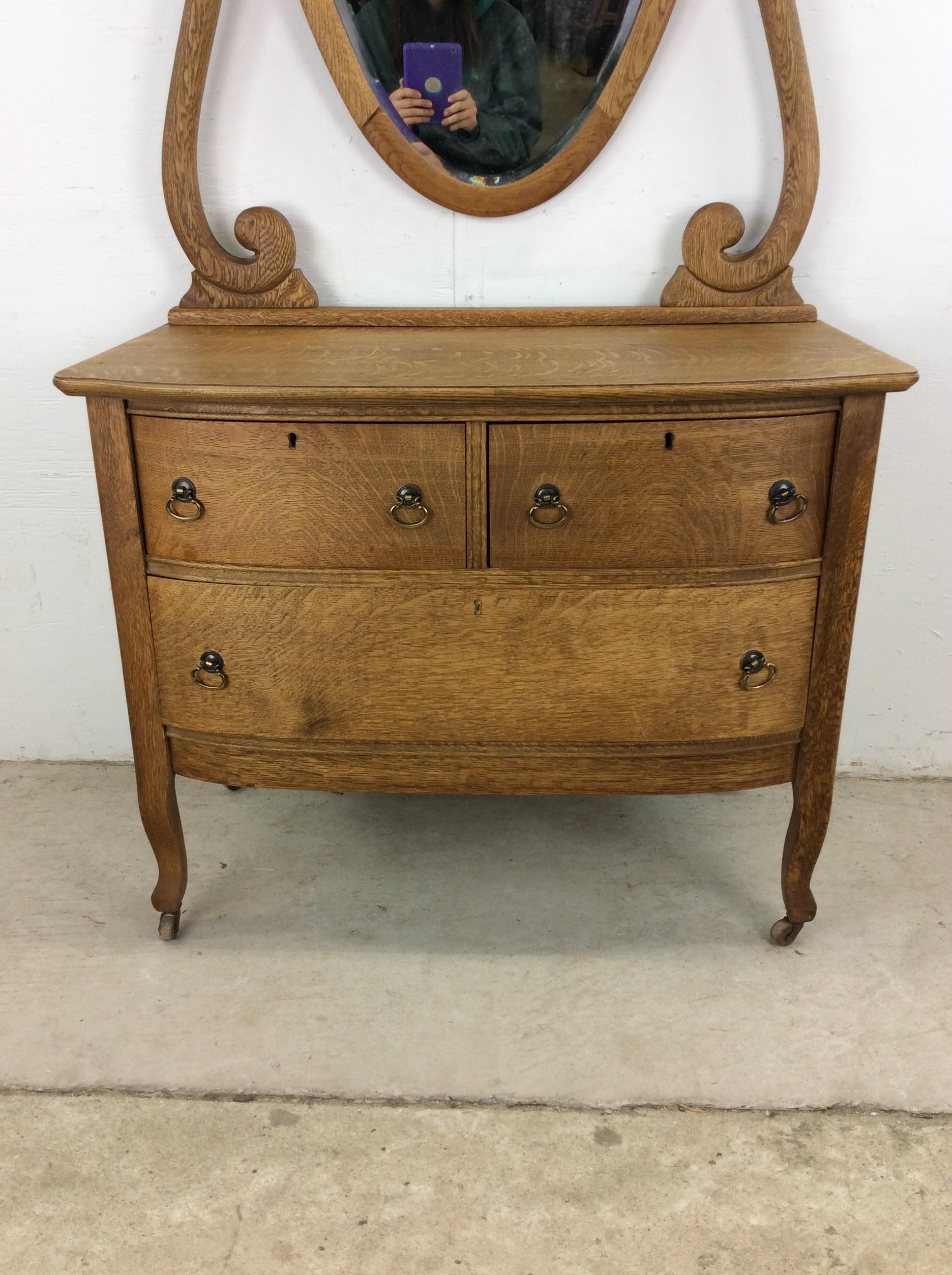 Esta cómoda victoriana antigua presenta una estructura de madera noble, un bonito acabado en roble, tres cajones de cola de milano con herrajes de latón, patas altas cónicas con ruedas de latón y un espejo antiguo montado.

Dimensiones: 34w 21d