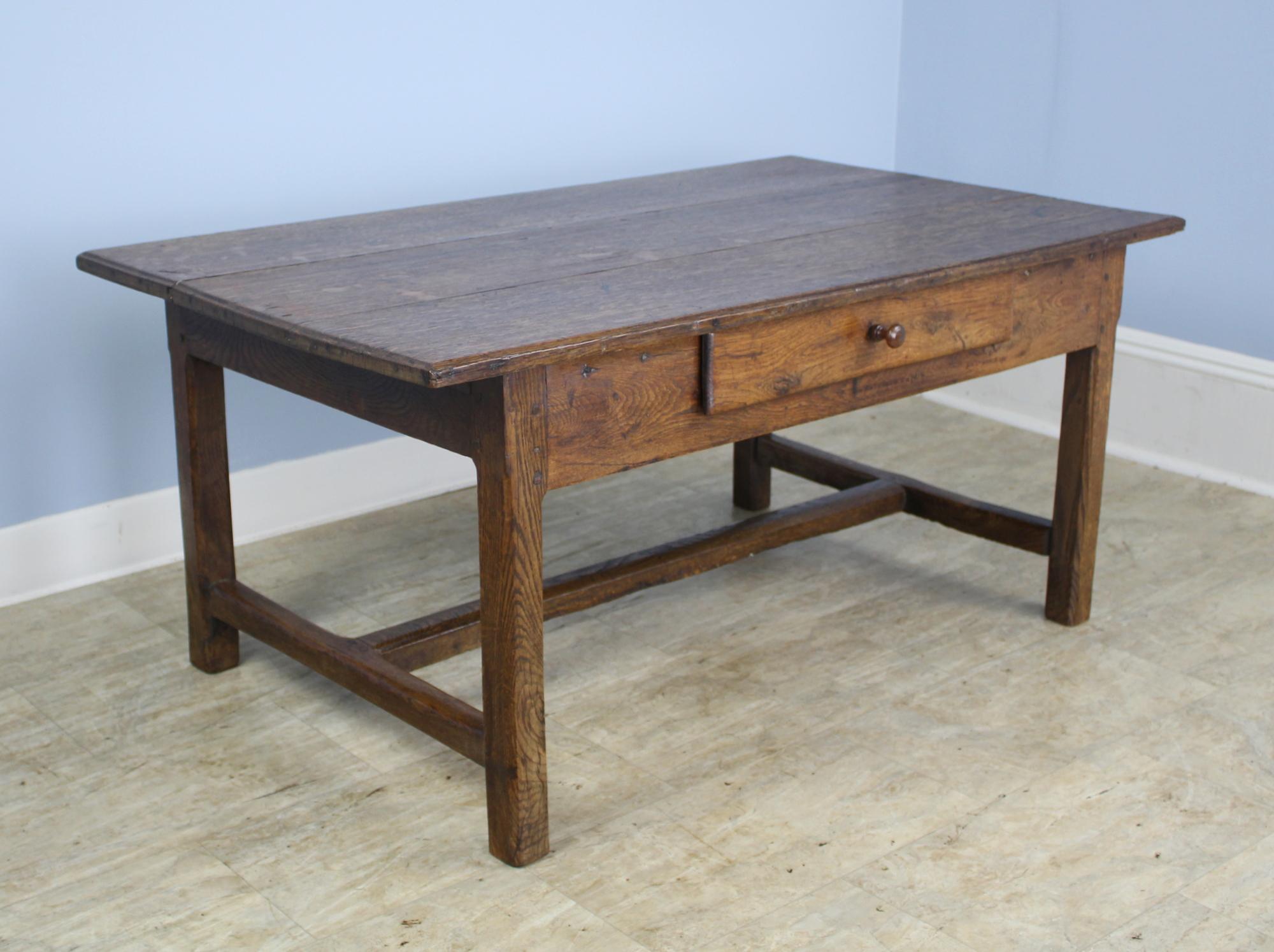 A nicely proportioned oak coffee table with a stretcher base. The wood has good color and patina and the single drawer adds a note of interest.