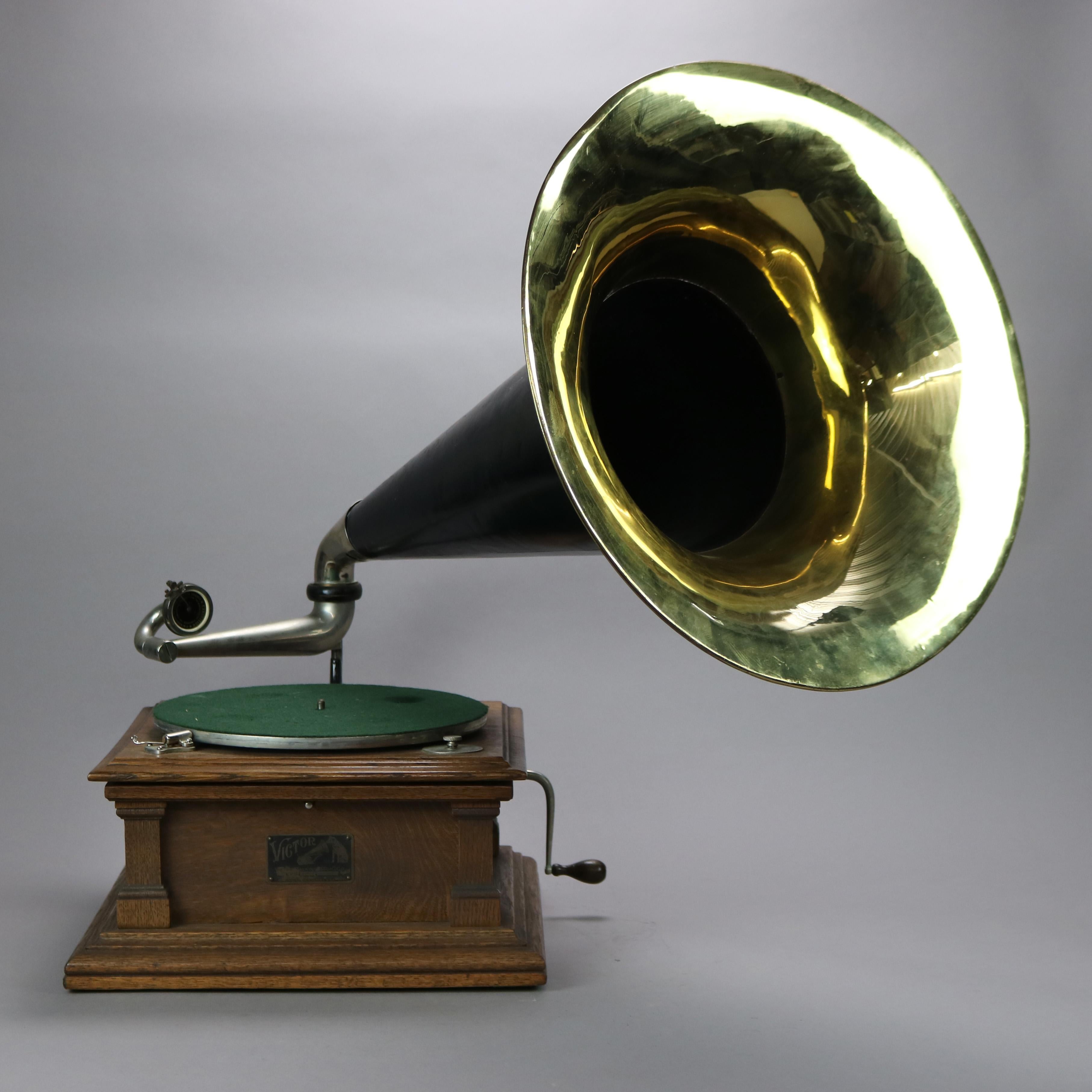 Antique Victor Model 5 (Vic V) phonograph offers quartersawn oak case with Doric style corners and brass bell horn, label as photographed, c1900. 

Measures - 31''H x 30.5''W x 31''D.