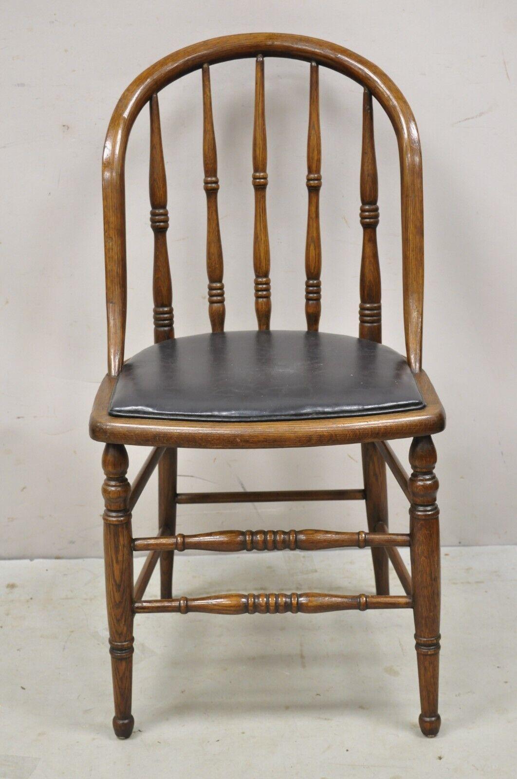 Antique Oak Wood Bowed Windsor dining side chair by Northwestern Mfg. Item features black vinyl upholstered seat (originally cane), turn carved legs, marked 
