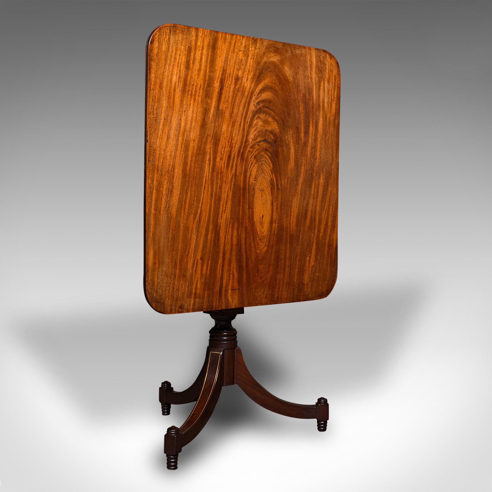 This is an antique occasional table. An English, mahogany tilt-top lamp or wine table, dating to the Regency period, circa 1820.

Distinctive appearance, with superb colour and appealing form
Displaying a desirable aged patina and in good