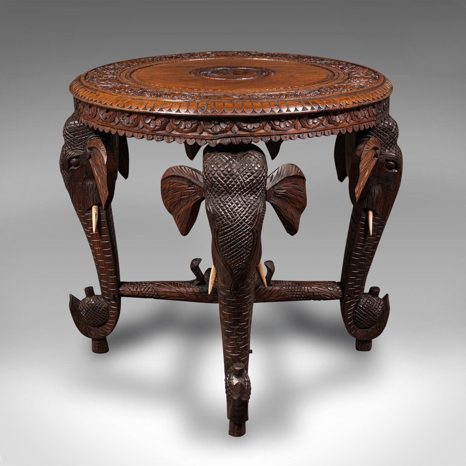 This is an antique occasional table. An Indian, solid teak carved coffee table with Elephant masks, dating to the late Victorian period, circa 1900.

Striking craftsmanship with superb decorative appeal
Displays a desirable aged patina and in good