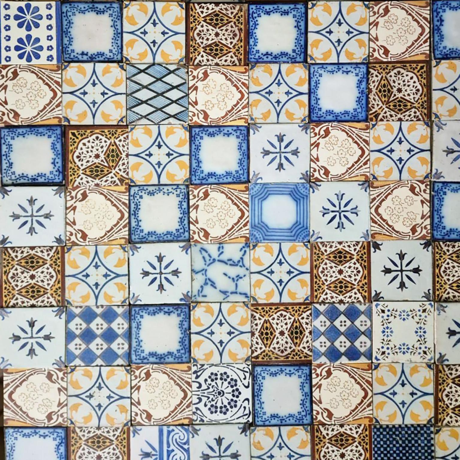 Beautiful handmade tiles in rich ochre and lightblue glazed colors with beautiful circular designs. Manufactured around 1920 by Gilliot Hemiksem, Belgium.  One tile set is divided in four squares, each symmetrically designed with a floral design.