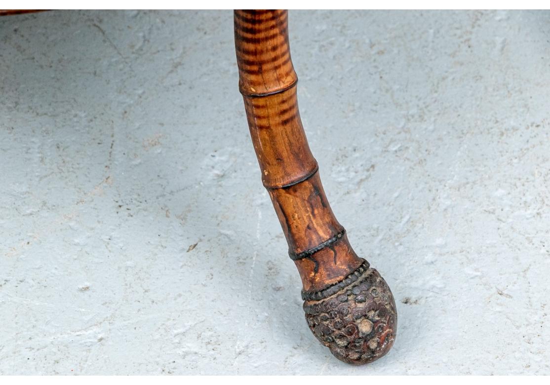 Une table ancienne en bambou très bien faite et très décorative avec des pieds pliés à la vapeur qui utilisent les racines du bambou.  de la canne de bambou en guise de pieds, l'étage inférieur est orné d'un travail d'osier très fin et complexe. 