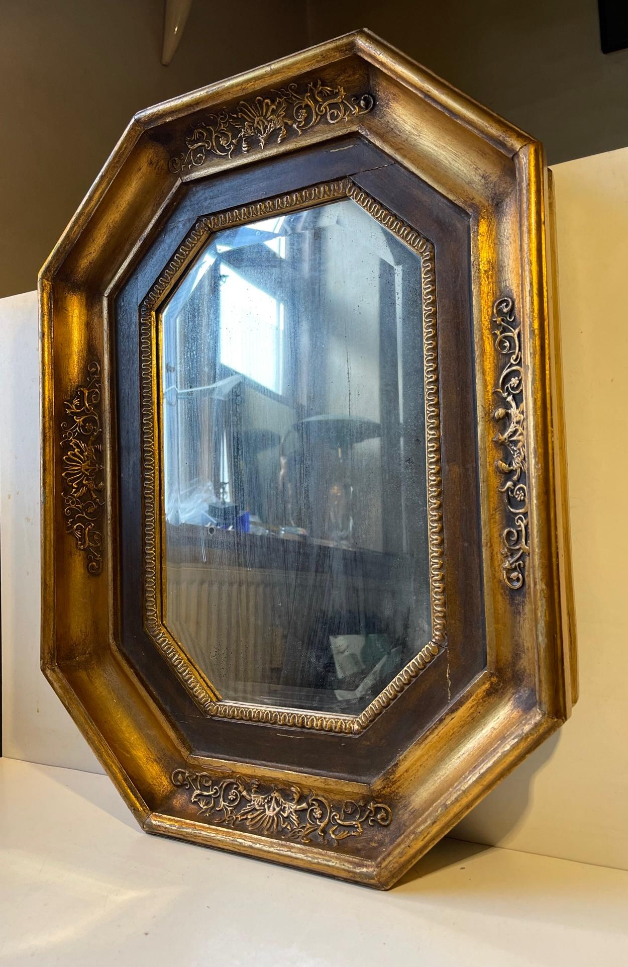 A medium sized octagonal wall mirror in gilt wood / oak. It was made in the mid-late 19th century Scandinavia - either in Denmark or Sweden. It features its original mercury mirror glass that has blurred up over the span of time. Together with the