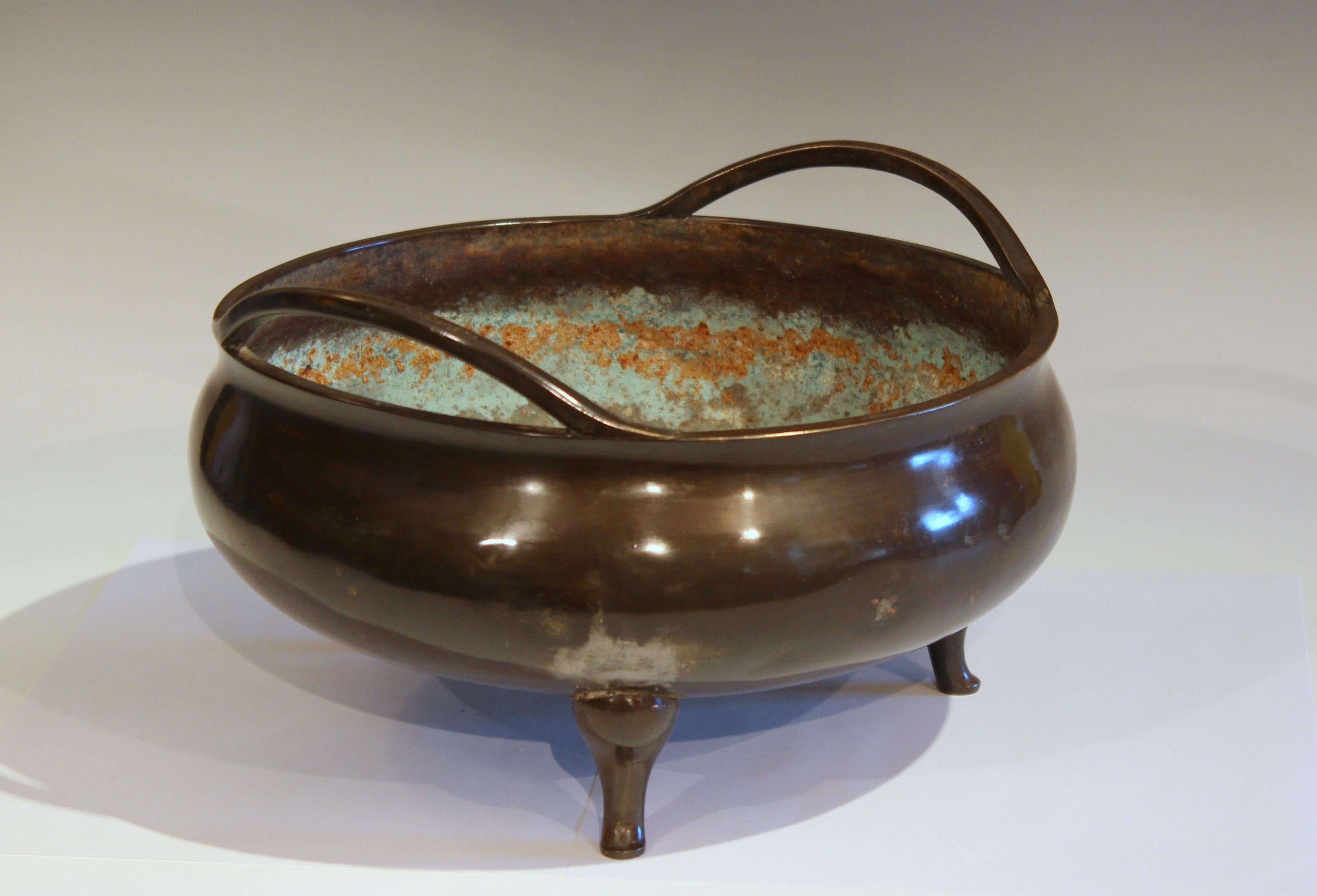 Old and large Chinese bronze censor bowl with great patina, circa 19th-early 20th century. On three feet with pair of undulating handles attached at the rim. 5+ pounds. 11