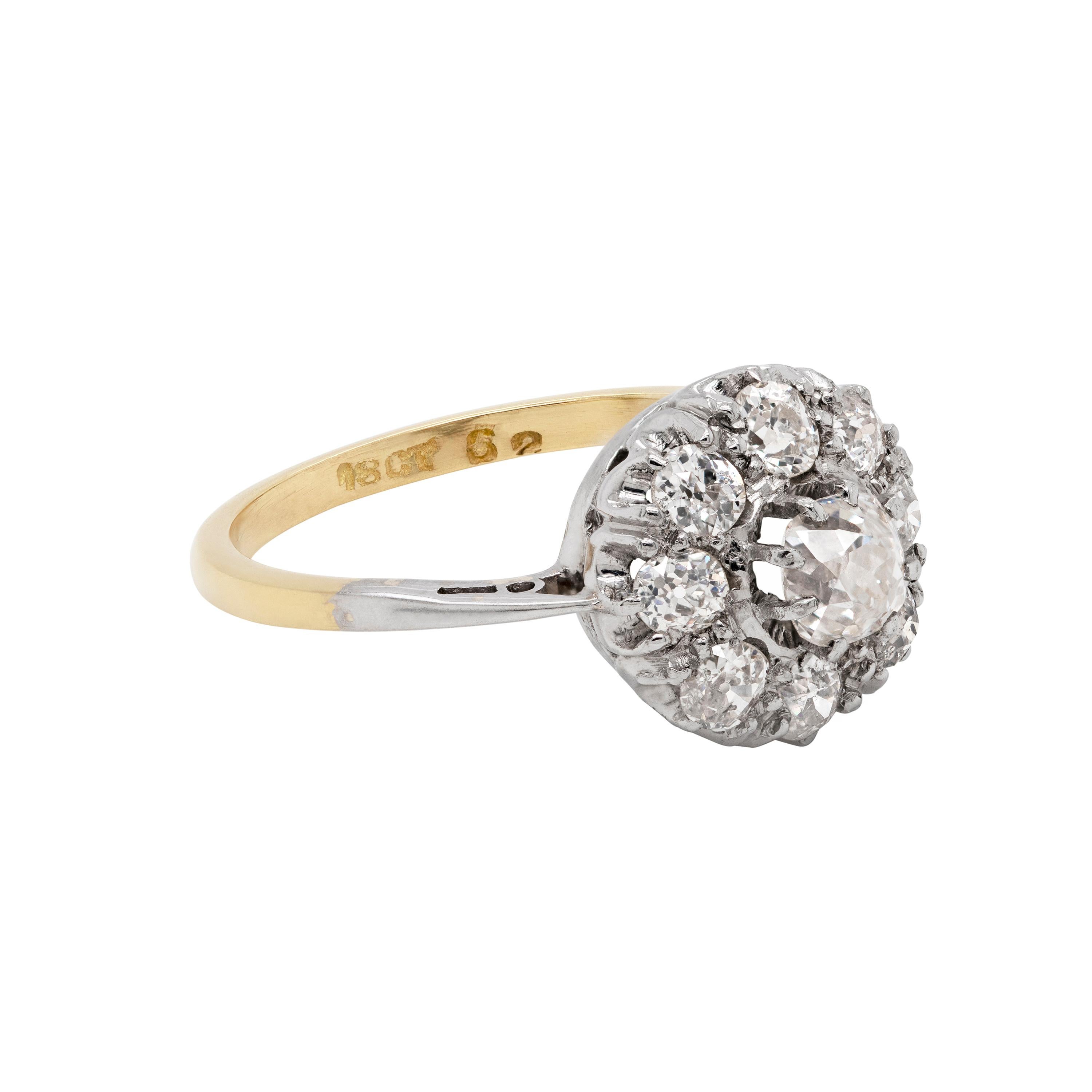 This beautiful cluster engagement ring features nine old mine cut diamonds, all claw set on a platinum collet, atop a 18ct yellow gold shank. The central old cut diamond, with a carat weight of 0.40ct, is beautifully surrounded by another eight old