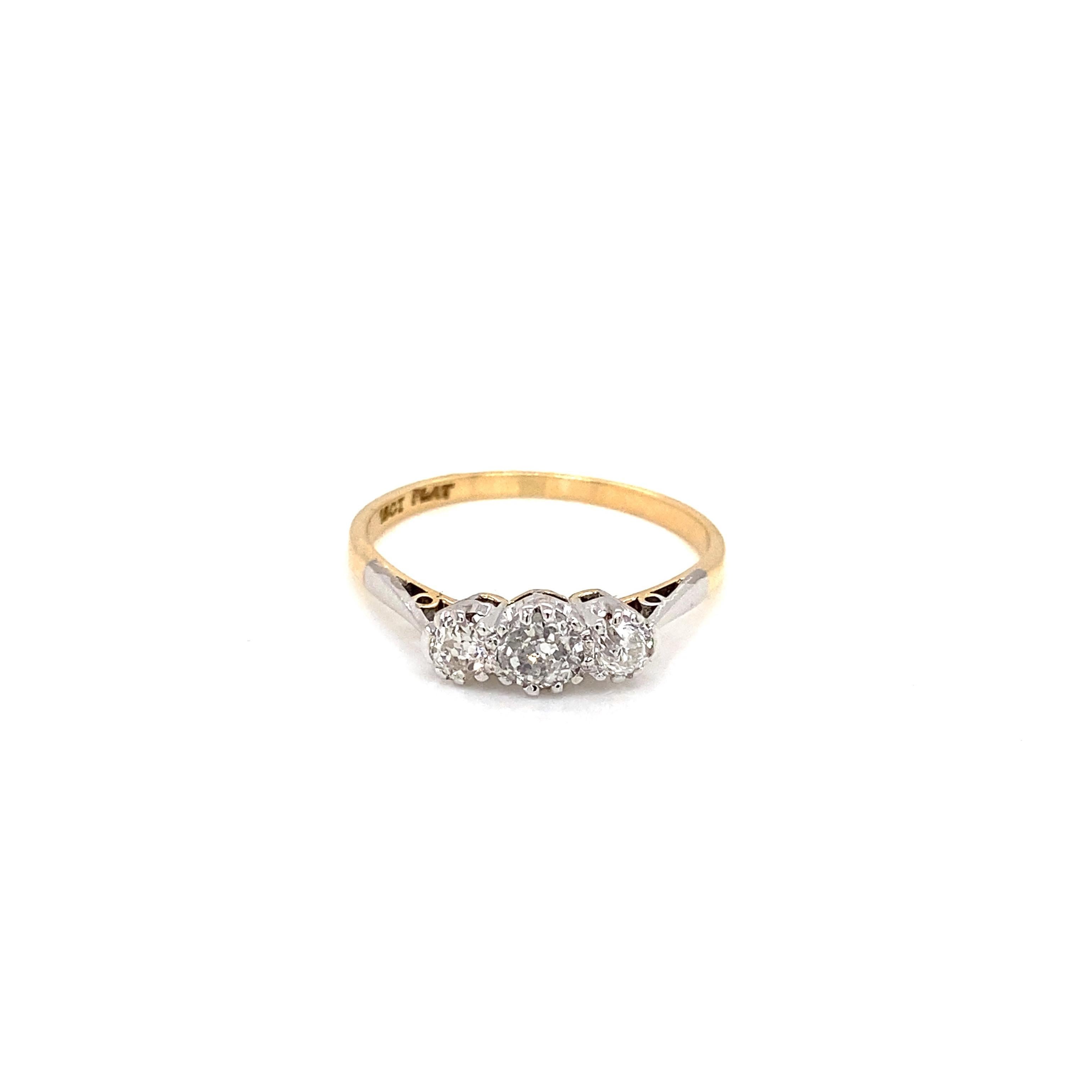 Ein exquisiter Verlobungsring mit drei Steinen aus der Edwardianischen Ära, meisterhaft gefertigt aus warmem 18 Karat Gelbgold und kühlem Platin.

Dieser klassische Ring präsentiert ein elegantes Trio aus Diamanten im Altminenschliff, die in einer