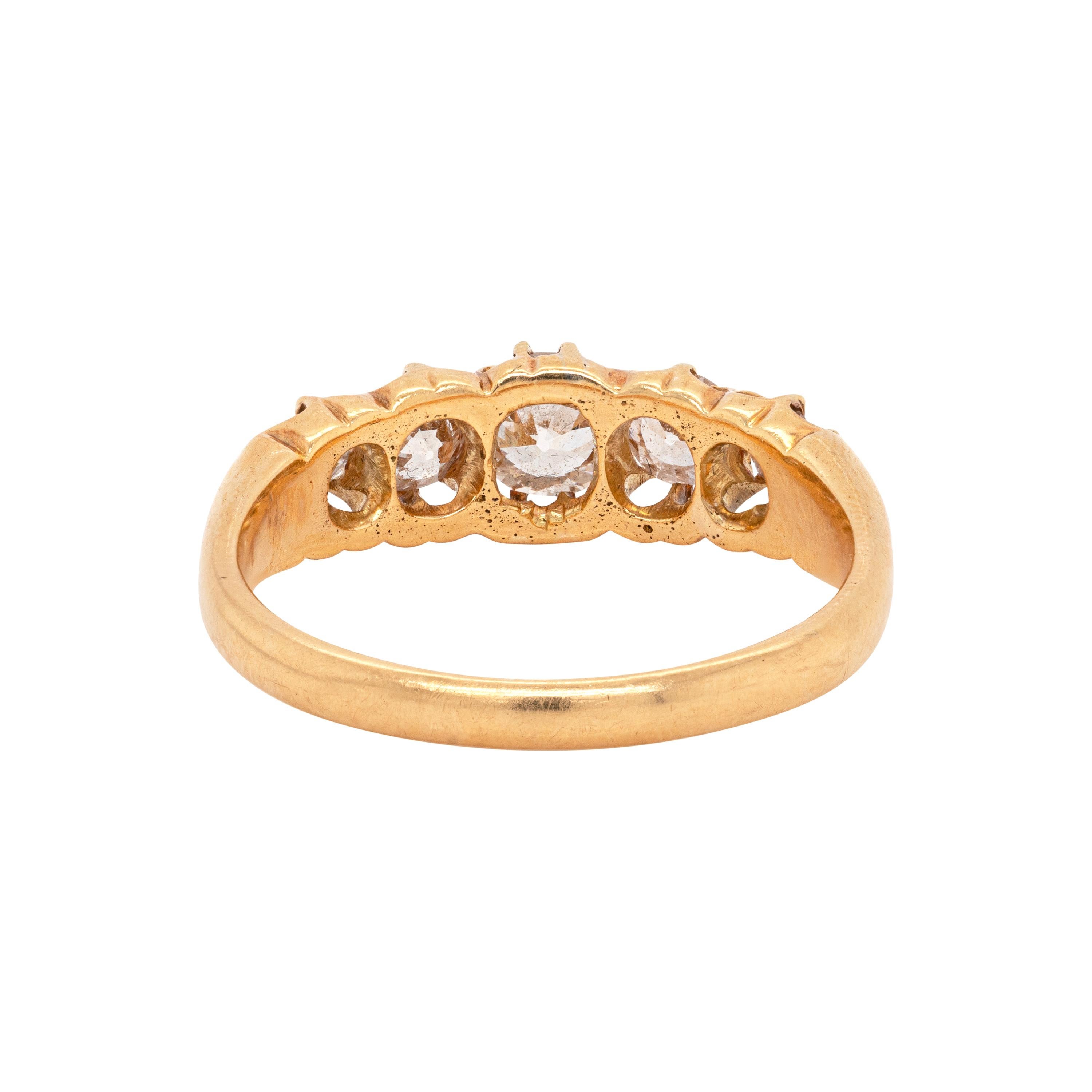 This antique Edwardian carved ring features five old cut diamonds with an approximate total weight of 1.20ct, all securely claw set in an open back 18 carat yellow gold setting. Five stone rings are said to represent the five qualities of a good