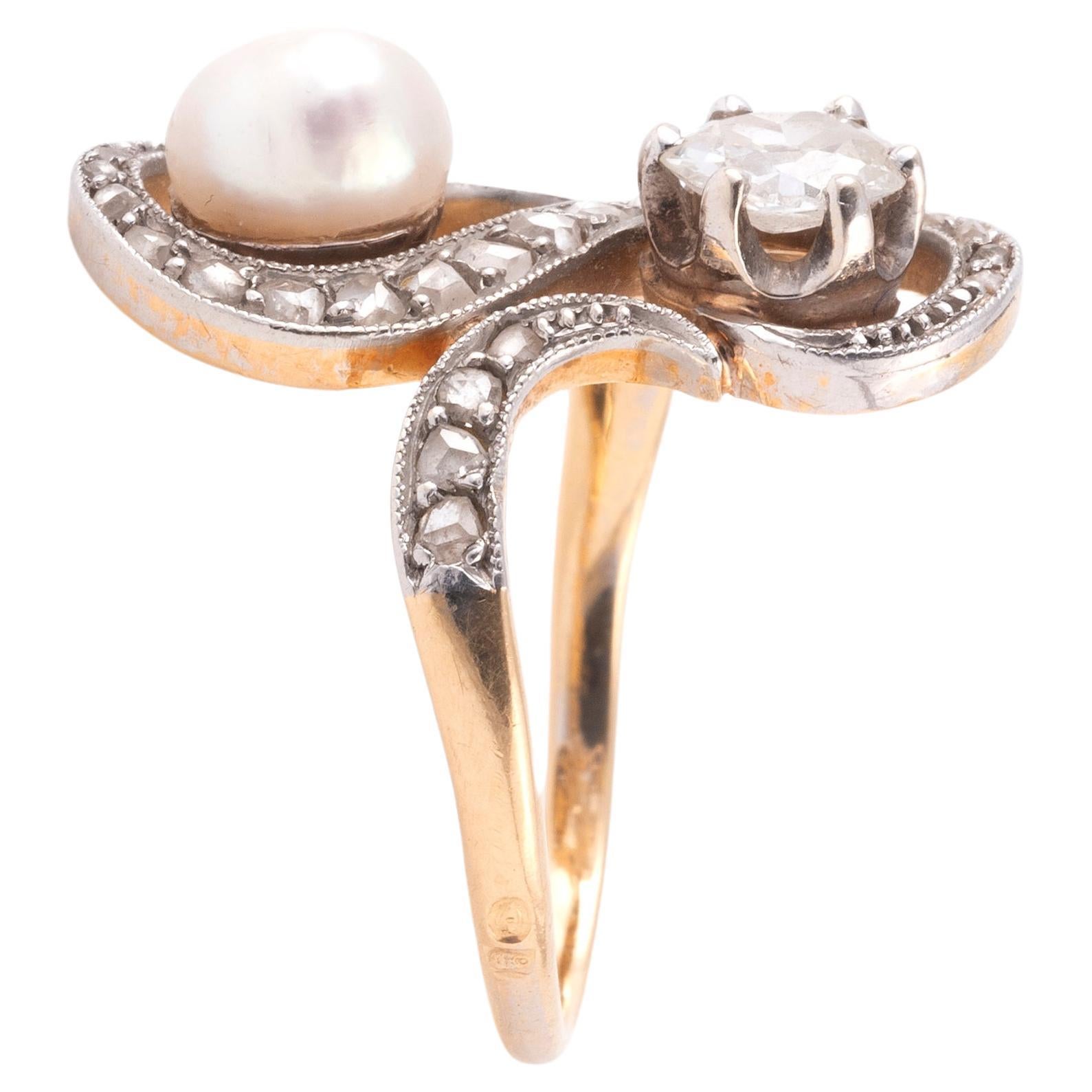 Toi et Moi ring in yellow gold 750 thousandths and platinum 850 thousandths, centered on a white button pearl and an old-cut diamond, underlined by scrolls set with rose-cut diamonds.
Pearl size: 5.5x6.6mm.
Main diamond weight: approx. 0.50