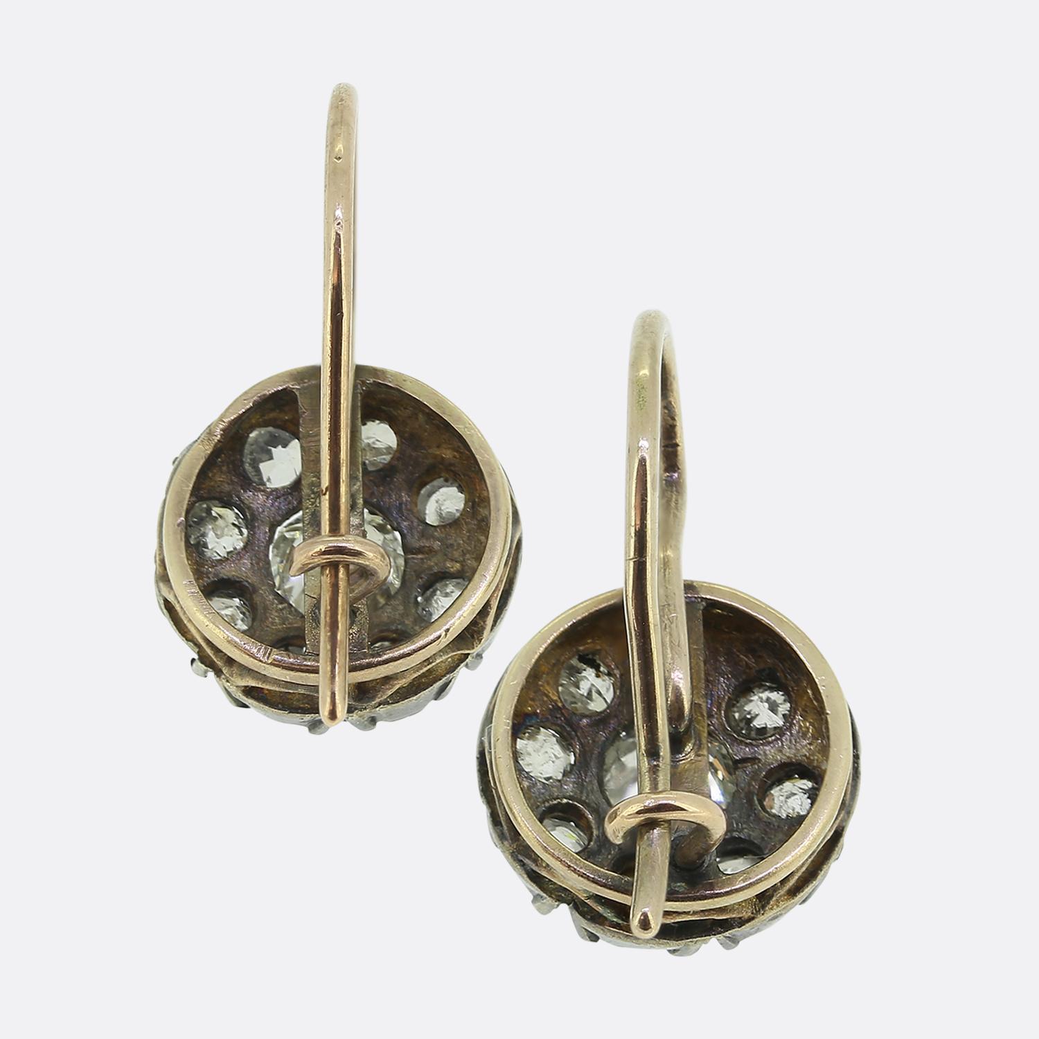 Here we have a gorgeous pair of diamond cluster earrings. Each identical piece showcases a centralised round faceted old mine cut diamond surrounded by a single row of smaller matching diamonds. Each stone has been individually claw set amidst a