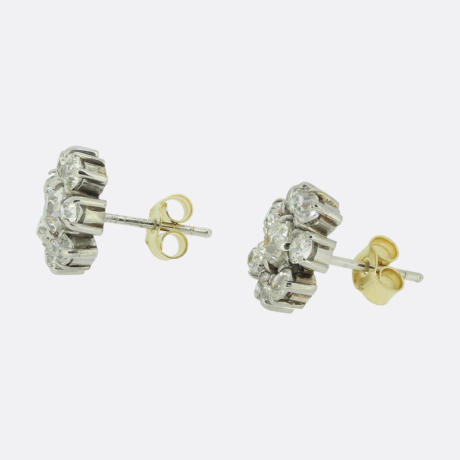 Here we have a delightful pair of diamond cluster earrings. Each earring features a centralised round faceted old mine cut diamond surrounded by a halo of smaller matching stones. Each diamond has been individually claw set in platinum to