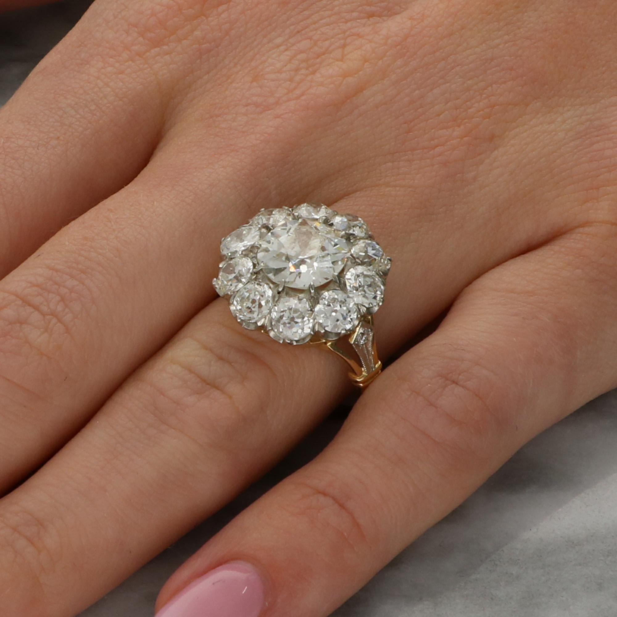 A beautiful vintage old cut diamond cluster ring set in 18k gold and platinum. 

The piece is centrally set with a sparkly 2.22 carat old cut diamond which is ten claw set securely. The central stone is then surrounded by a cluster of ten further