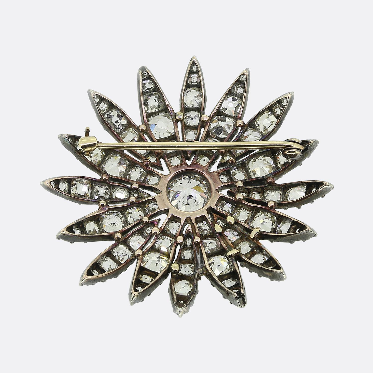 Here we have a stunning diamond brooch taken from the Victorian period. This antique piece has been crafted from 18ct gold and silver to form a radiant floral design. At its heart lies a central old cushion cut diamond, surrounded by a dazzling