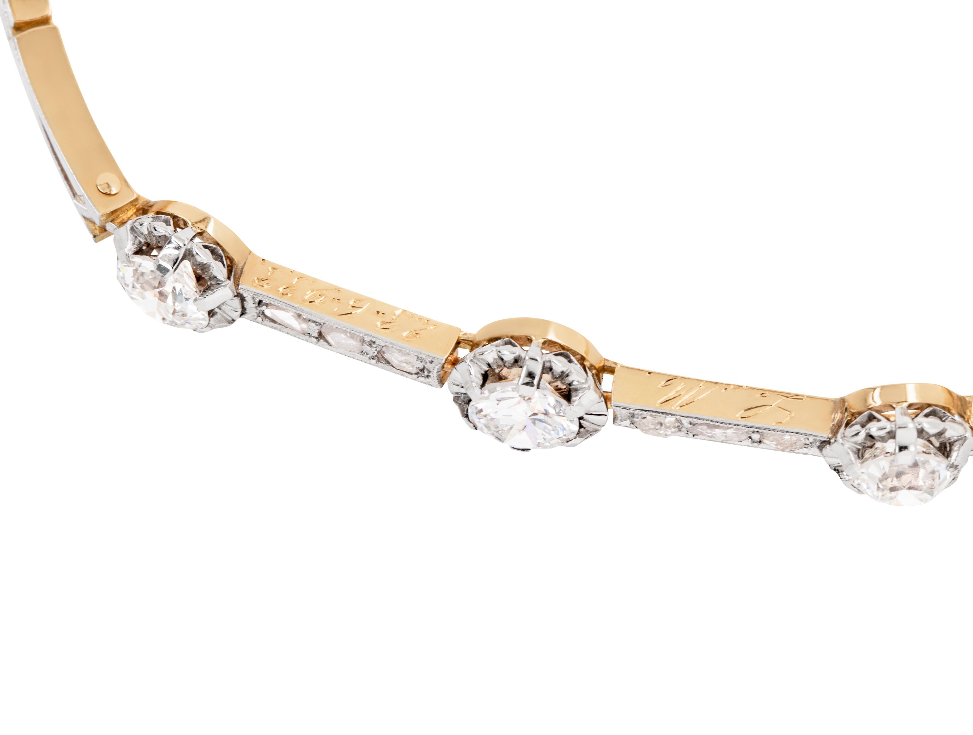 This stunning bracelet features three large old cut diamonds weighing a combined approximate weight of 1.50 carats, each mounted in platinum illusion settings, typical of the Edwardian period. Between the stones are two flat bars inlaid with three