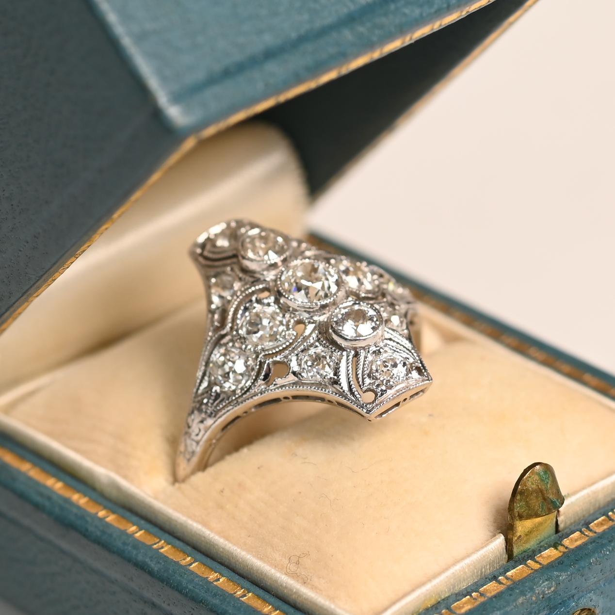 Dieser exquisite antike Ring aus Platin, der in der ikonischen Ära des Art déco (um 1920) handgefertigt wurde, zeichnet sich durch zeitlose Eleganz und meisterhafte Handwerkskunst aus. In seiner Mitte sind drei in die Lünette gefasste Diamanten im