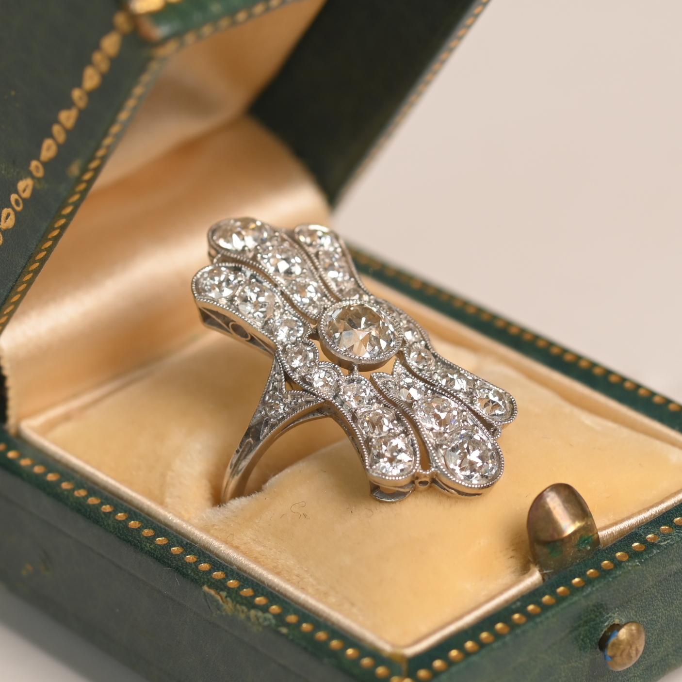Cette exquise bague allongée originale de style Art déco est un véritable chef-d'œuvre de l'artisanat du début du XXe siècle, mettant en valeur l'élégance intemporelle de l'époque. Fabriquée à la main vers 1920, la bague présente un design filigrane