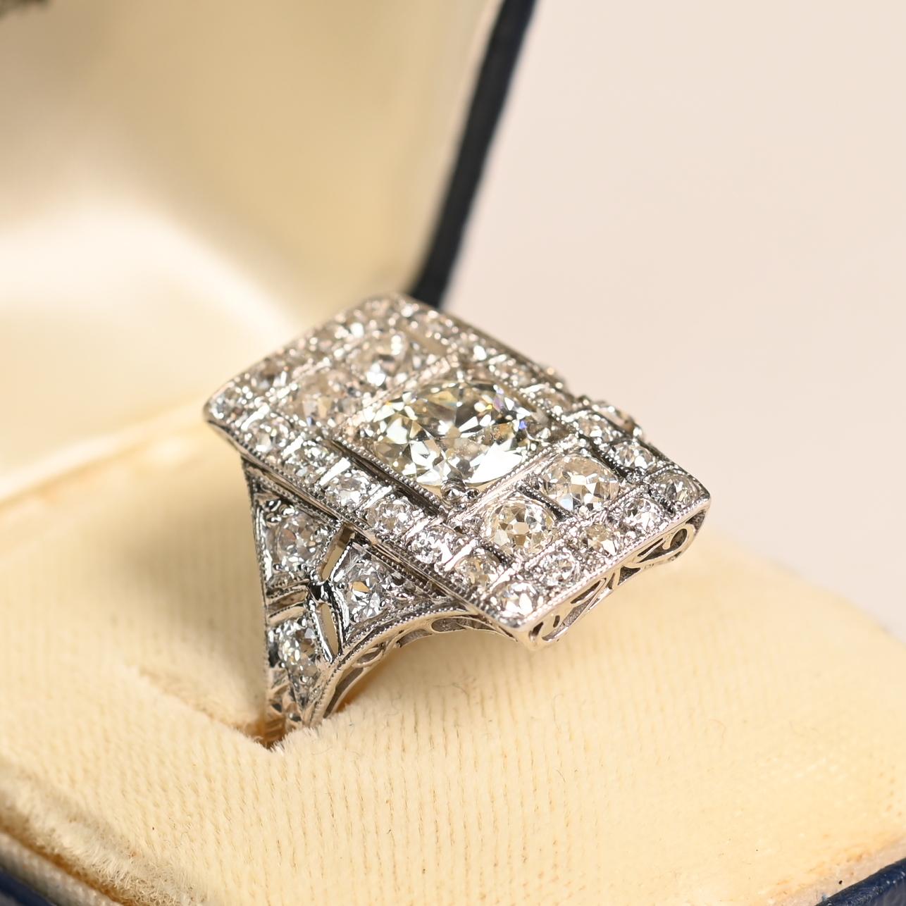 Dieser exquisite Art-Déco-Ring aus der Zeit um 1920 zeigt in seiner Mitte einen atemberaubenden Diamanten im alten europäischen Schliff von 1,45 Karat. Der Diamant mit der Farbe J und der Reinheit VS1 ist in eine quadratische Lünette gefasst, die