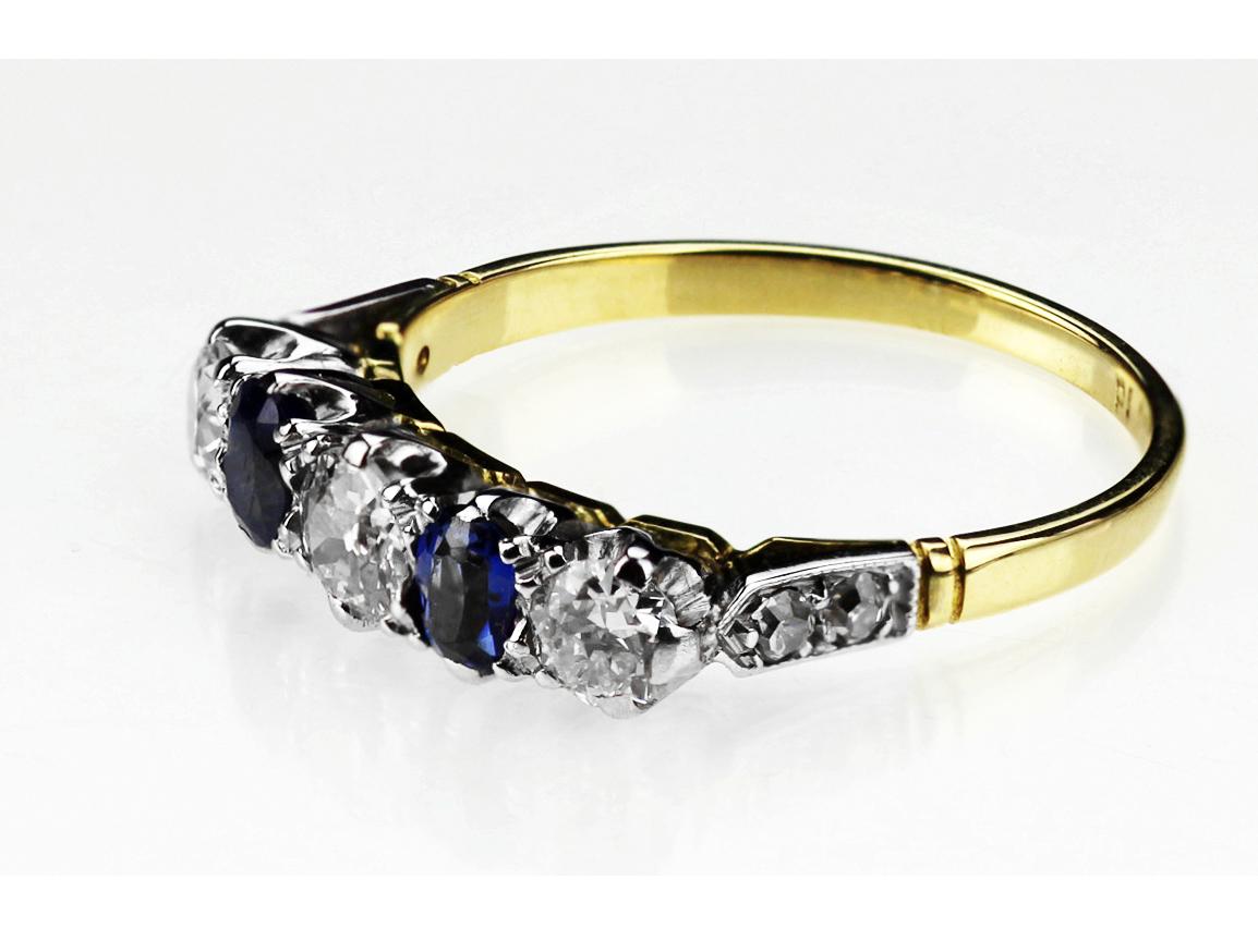 A beautiful five-stone sapphire and diamond antique ring with pave diamond shoulders to a plain 18 carat yellow gold mount with platinum. The Old-European Cut diamonds are separated by two cushion-cut natural sapphires with smaller diamonds on the