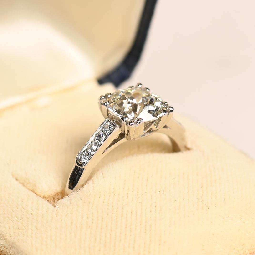 Este extraordinario anillo de compromiso antiguo ejemplifica la elegancia atemporal, con un diamante de talla europea antigua certificado por el GIA como pieza central. El diamante, de un impresionante peso aproximado de 2,00 quilates, tiene una