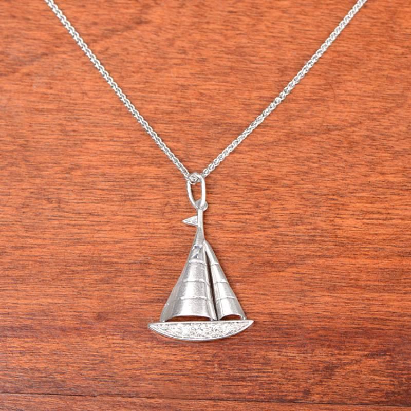 Embark on a journey through time with this original Art Deco sailboat charm necklace. Crafted with utmost artistry, this nautical-themed charm necklace captures the essence of the open sea. The bottom half of the sailboat is adorned with exquisite